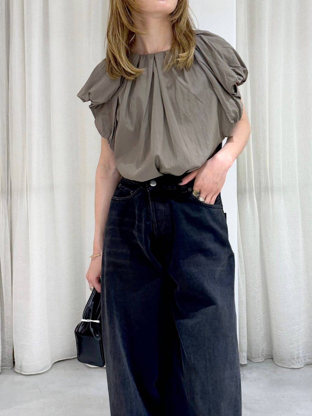 ブラック系のデニムパンツ、ベージュ系のシャツ/ブラウスを着用したレディースの夏コーディネートの6枚目の写真