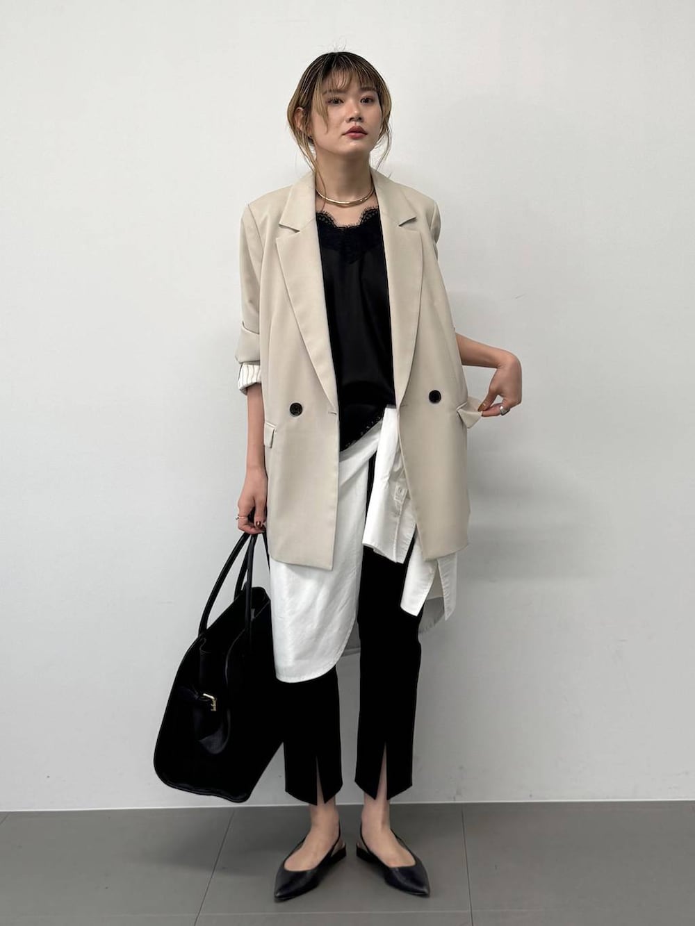 ブラック系のボストンバッグ、ベージュ系のテーラードジャケット、ブラック系のその他パンツを着用したレディースの春コーディネートの3枚目の写真