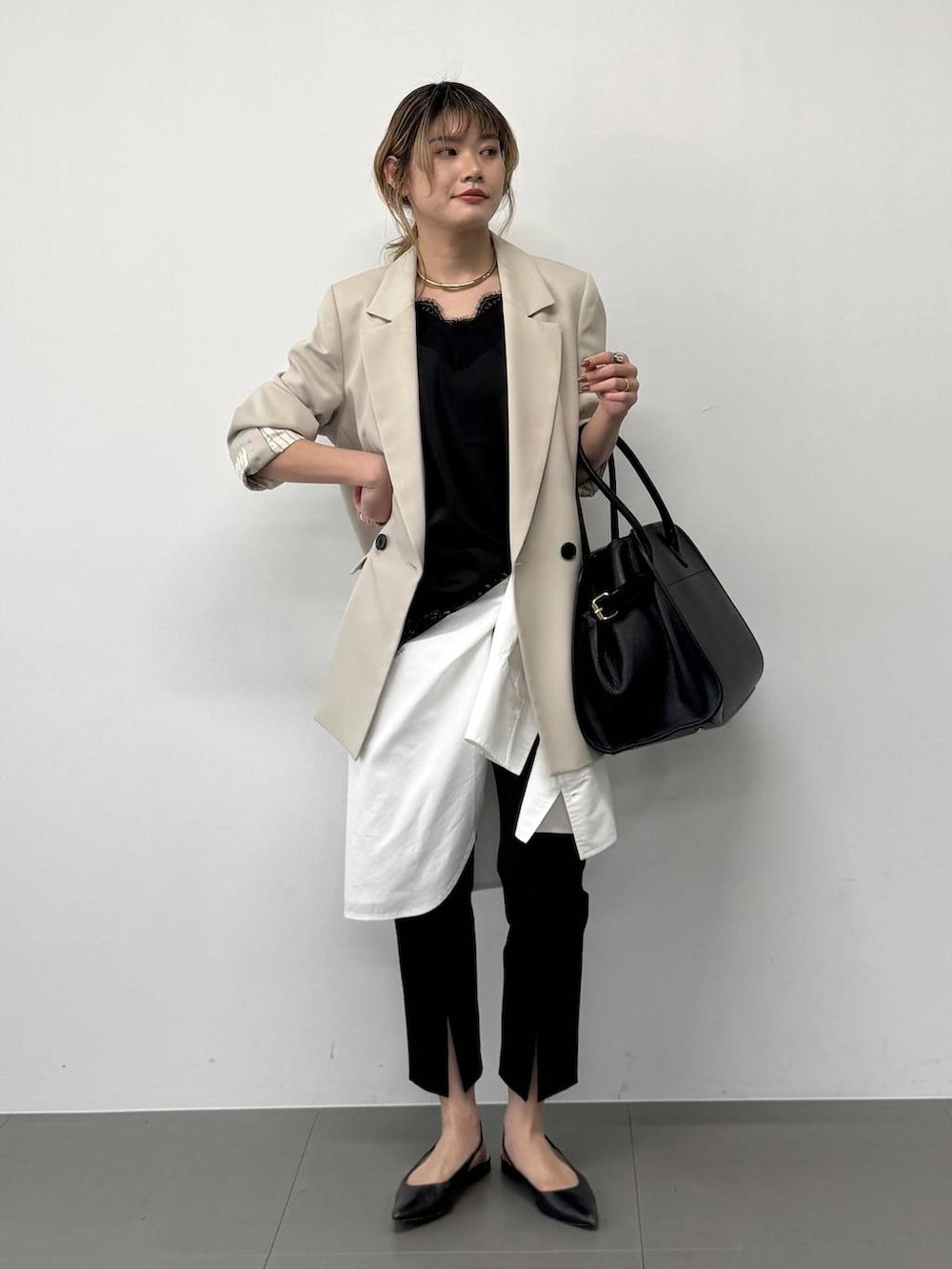 ブラック系のボストンバッグ、ベージュ系のテーラードジャケット、ブラック系のその他パンツを着用したレディースの春コーディネートの4枚目の写真