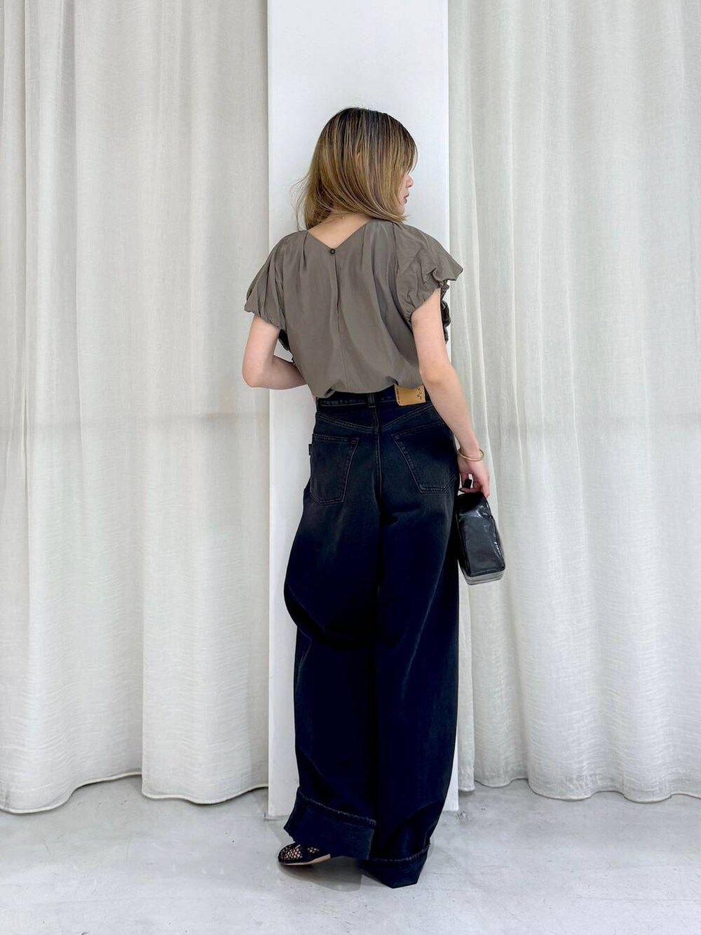 ブラック系のデニムパンツ、ベージュ系のシャツ/ブラウスを着用したレディースの夏コーディネートの5枚目の写真