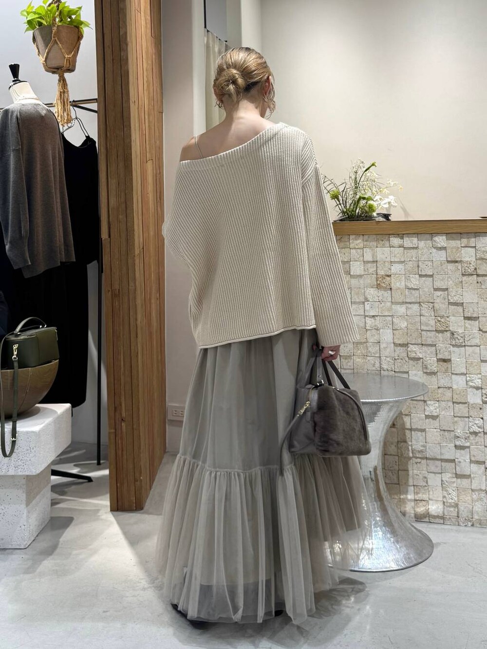 ブラウン系のハンドバッグ、ベージュ系のニット/セーター、ベージュ系のスカートを着用したレディースの冬コーディネートの5枚目の写真