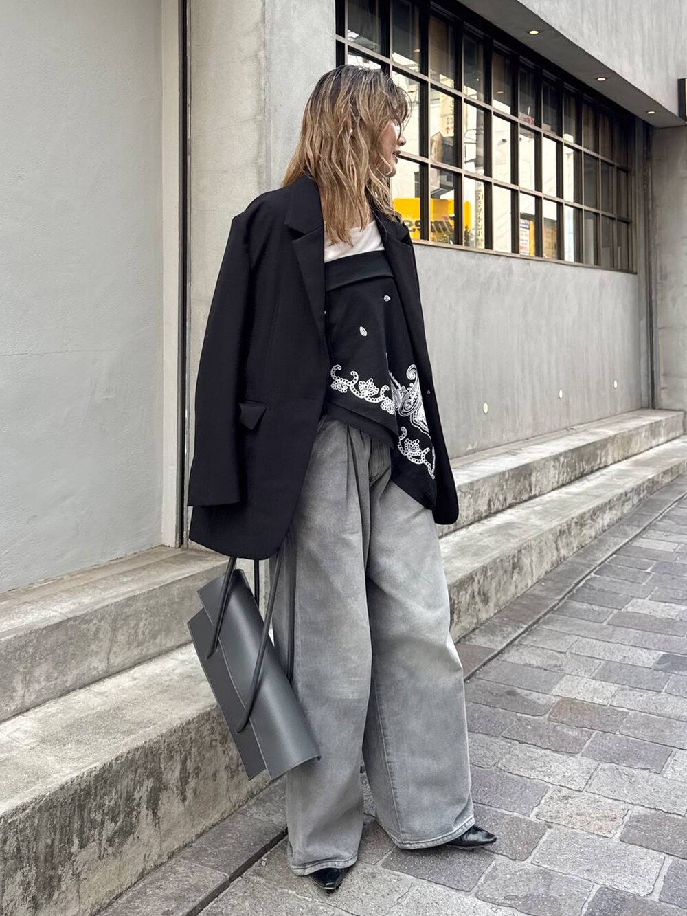 グレー系のデニムパンツ、ブラック系のテーラードジャケット、ホワイト系のTシャツ/カットソーを着用したレディースの春コーディネートの2枚目の写真