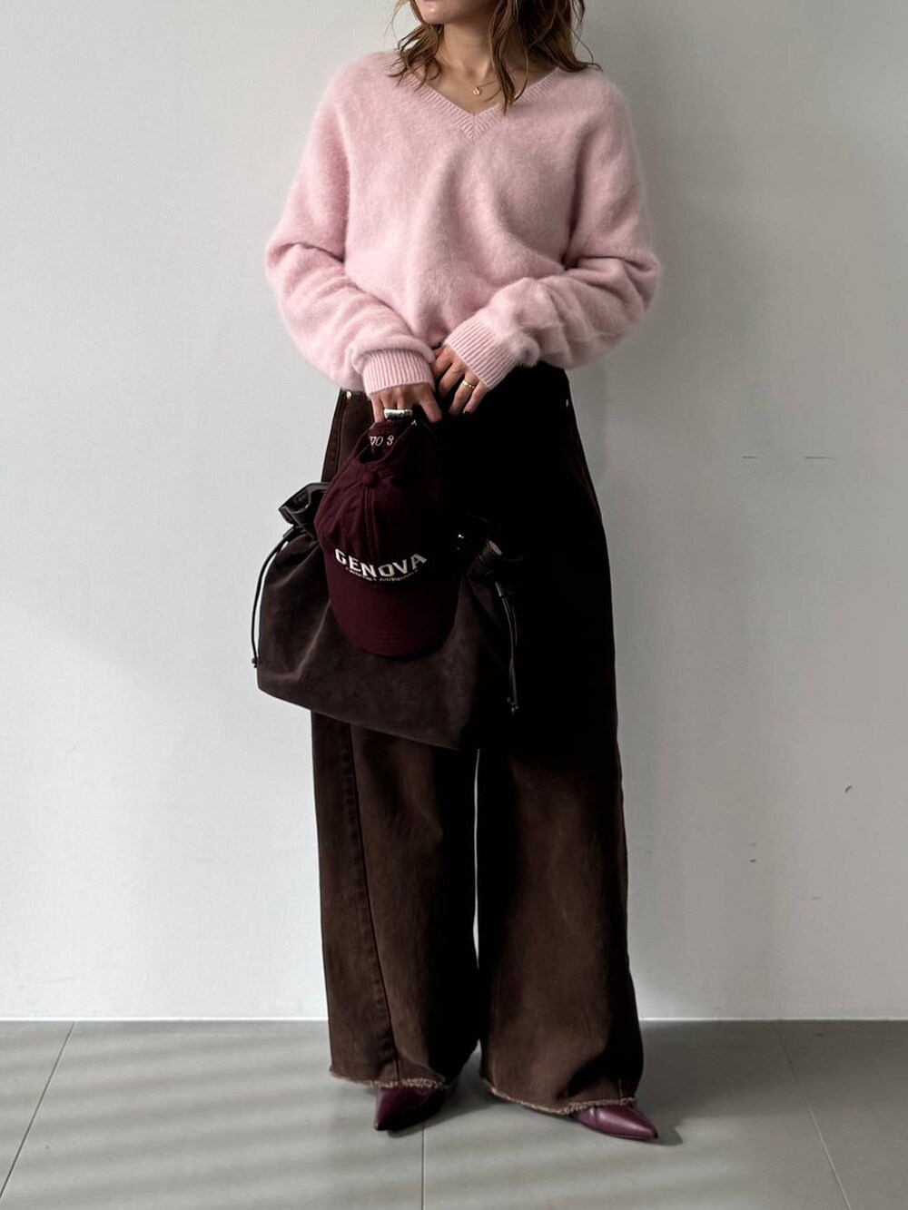 ピンク系のニット/セーター、レッド系のブーツ、ブラウン系のトートバッグを着用したレディースの秋コーディネートの3枚目の写真