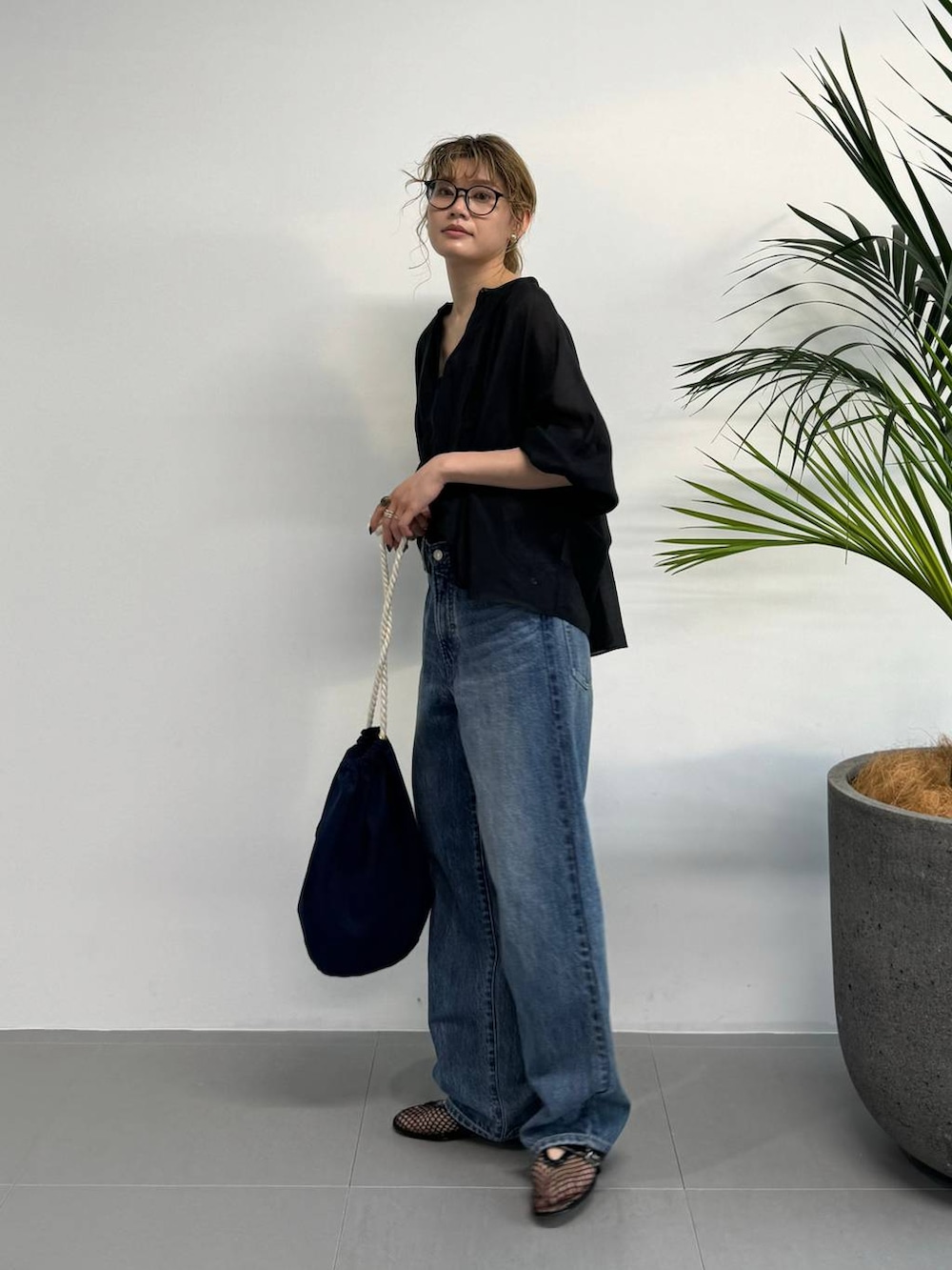 ブラック系のシャツ/ブラウス、ブルー系のデニムパンツ、ブルー系のハンドバッグを着用したレディースの夏コーディネートの5枚目の写真