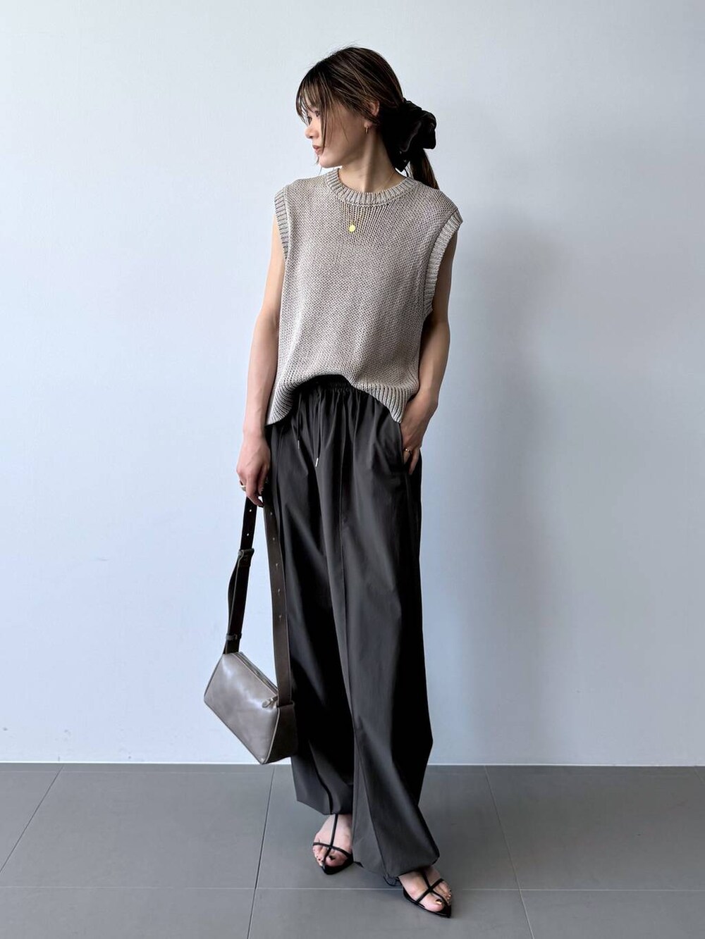 ブラック系のサンダル、グレー系のその他パンツ、ベージュ系のTシャツ/カットソーを着用したレディースの春コーディネートの3枚目の写真