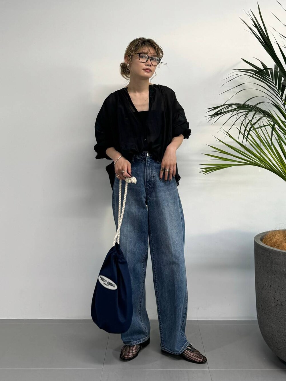 ブラック系のシャツ/ブラウス、ブルー系のデニムパンツ、ブルー系のハンドバッグを着用したレディースの夏コーディネートの7枚目の写真