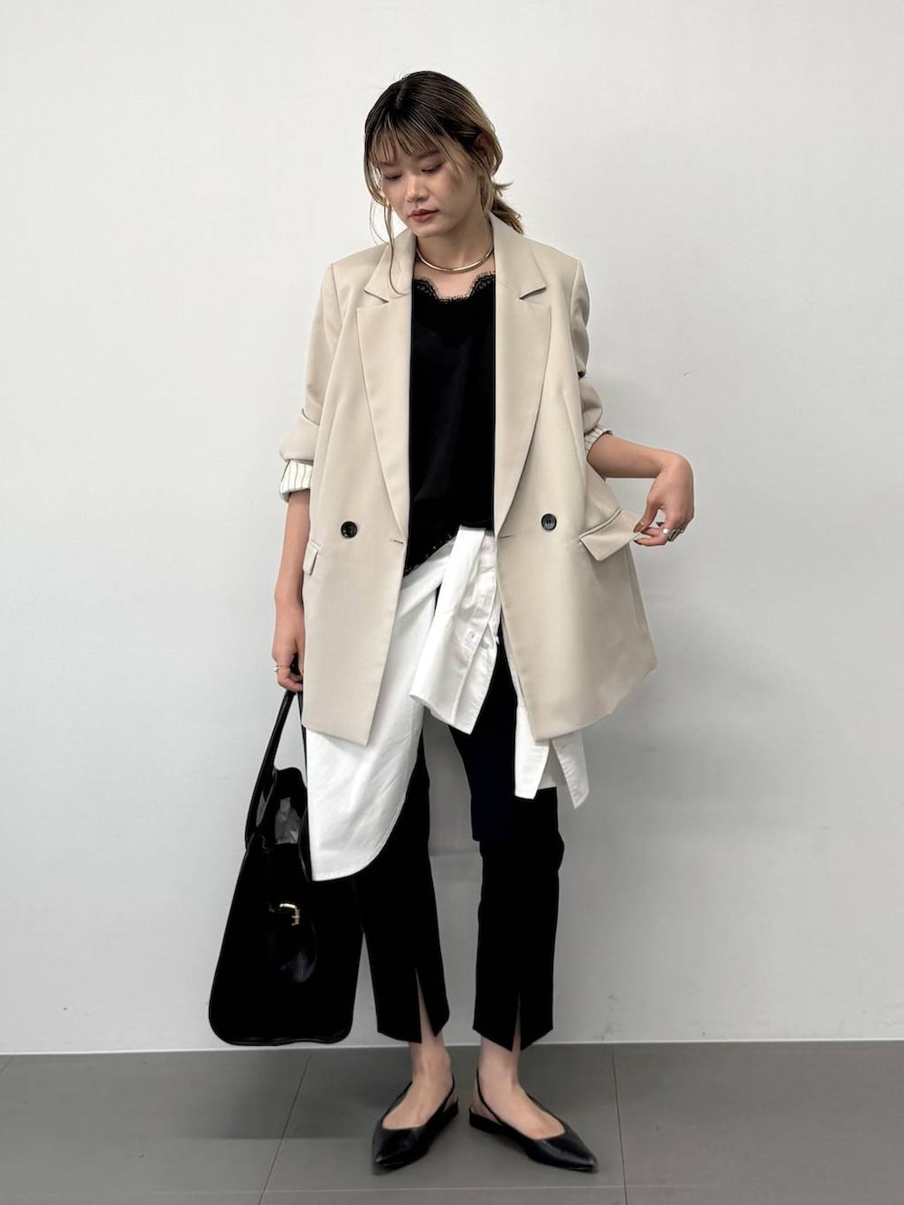 ブラック系のボストンバッグ、ベージュ系のテーラードジャケット、ブラック系のその他パンツを着用したレディースの春コーディネートの2枚目の写真