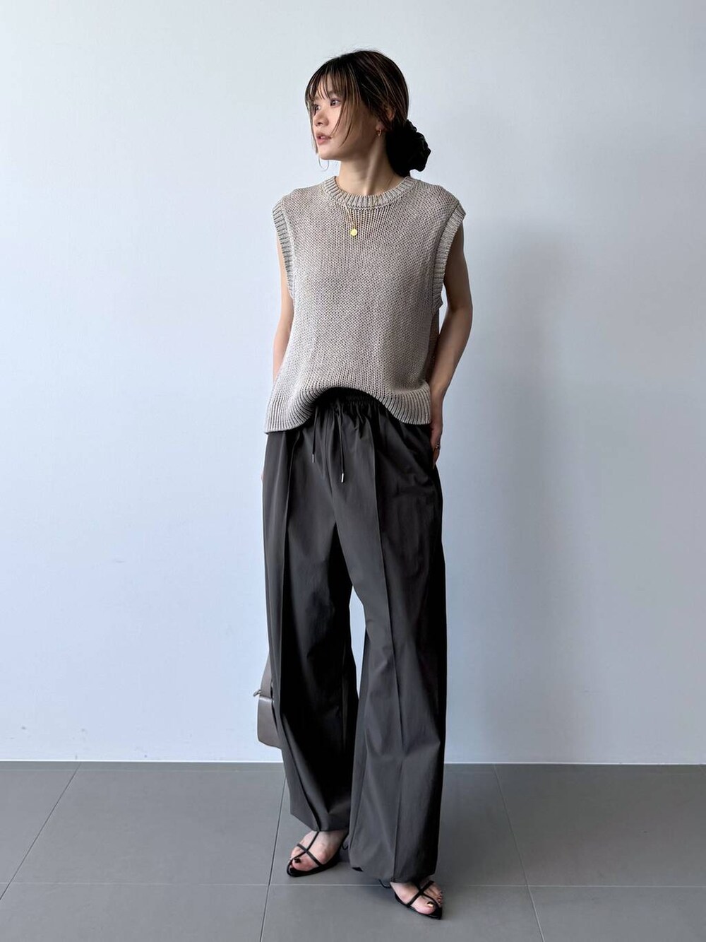 ブラック系のサンダル、グレー系のその他パンツ、ベージュ系のTシャツ/カットソーを着用したレディースの春コーディネートの5枚目の写真