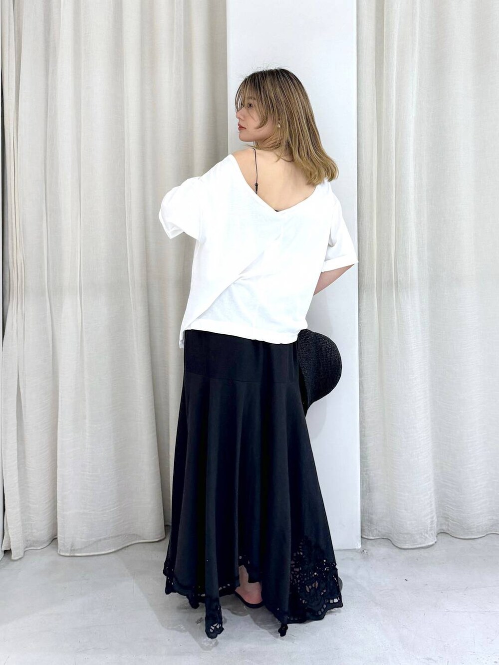 ブラック系のスカート、ブラック系のサンダル、ホワイト系のTシャツ/カットソーを着用したレディースの夏コーディネートの5枚目の写真