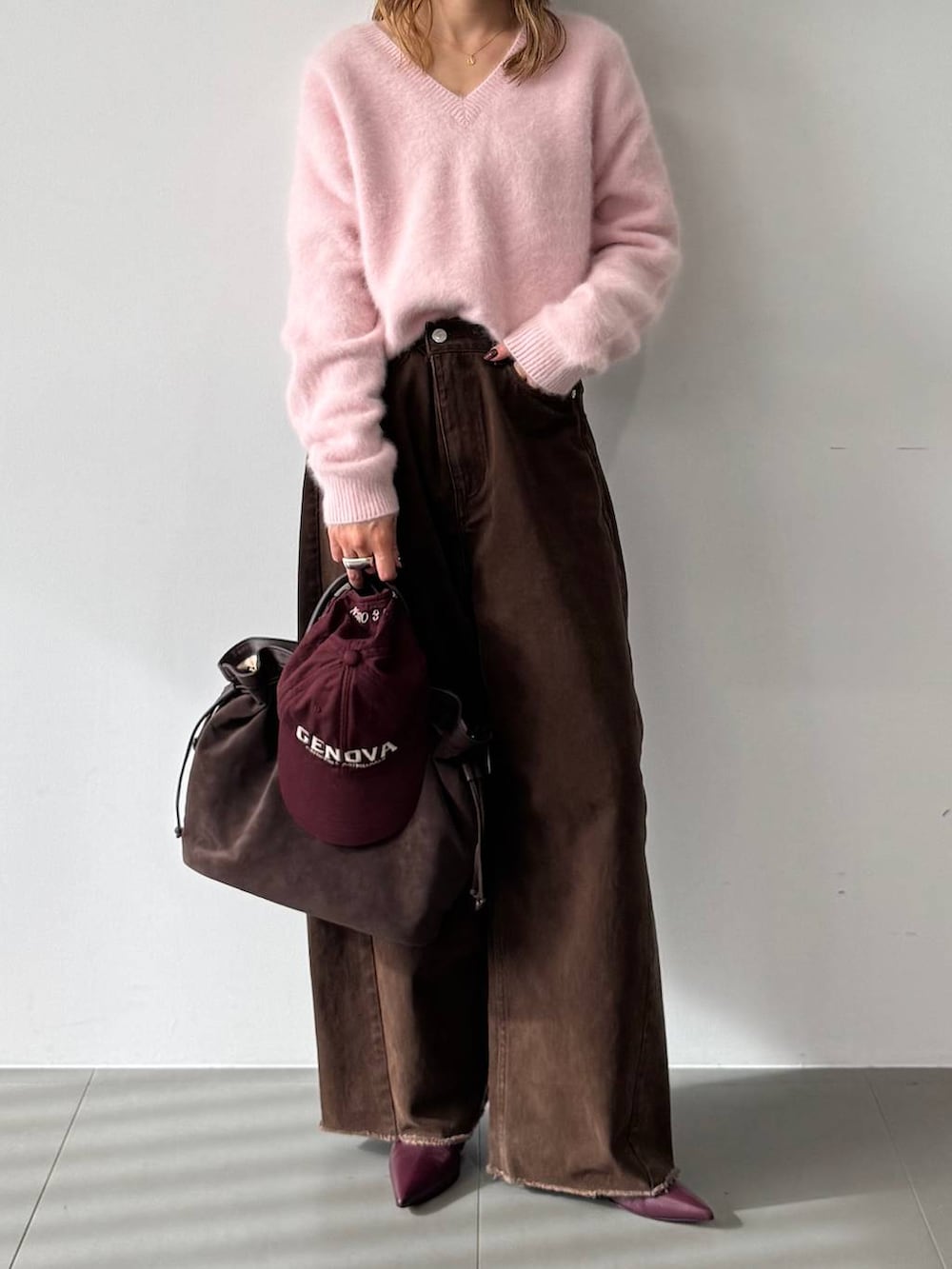 ピンク系のニット/セーター、レッド系のブーツ、ブラウン系のトートバッグを着用したレディースの秋コーディネートの6枚目の写真