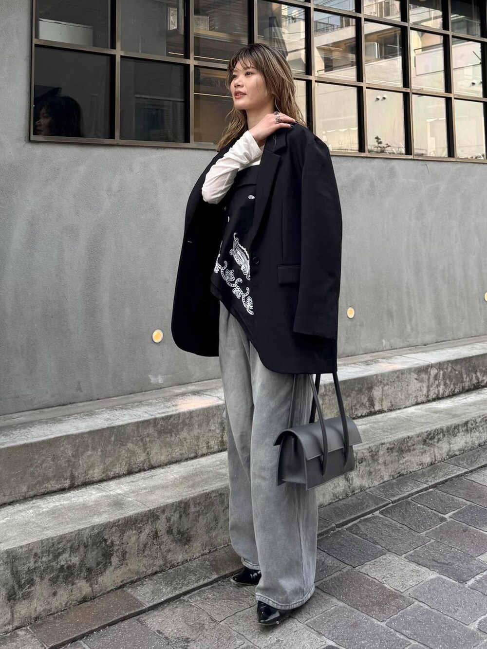 グレー系のデニムパンツ、ブラック系のテーラードジャケット、ホワイト系のTシャツ/カットソーを着用したレディースの春コーディネートの5枚目の写真