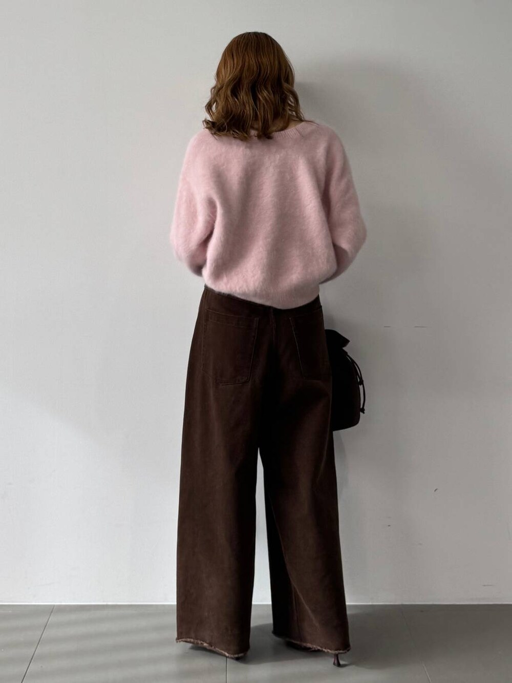 ピンク系のニット/セーター、レッド系のブーツ、ブラウン系のトートバッグを着用したレディースの秋コーディネートの5枚目の写真