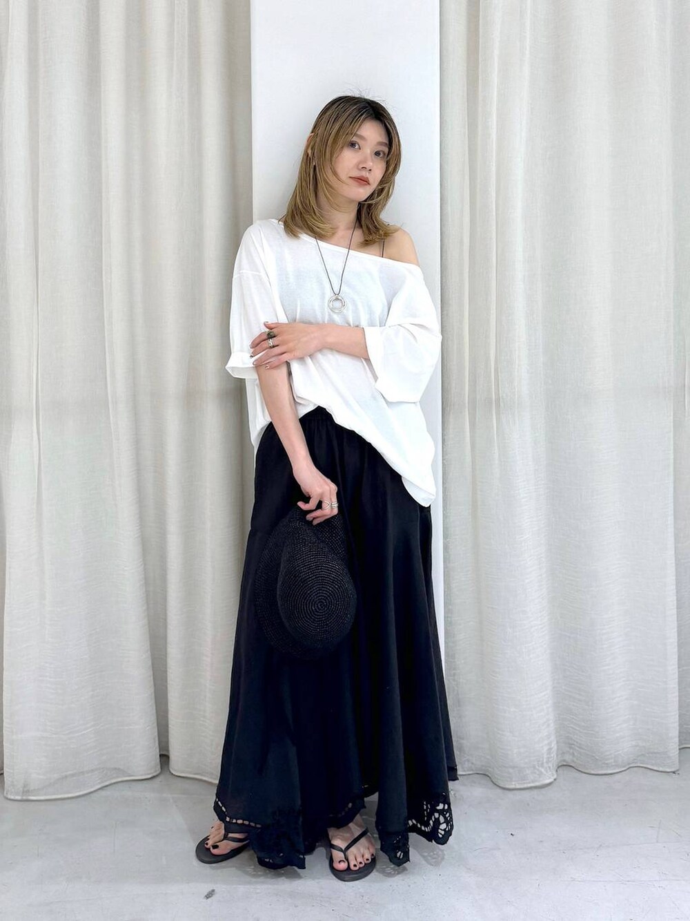 ブラック系のスカート、ブラック系のサンダル、ホワイト系のTシャツ/カットソーを着用したレディースの夏コーディネートの3枚目の写真