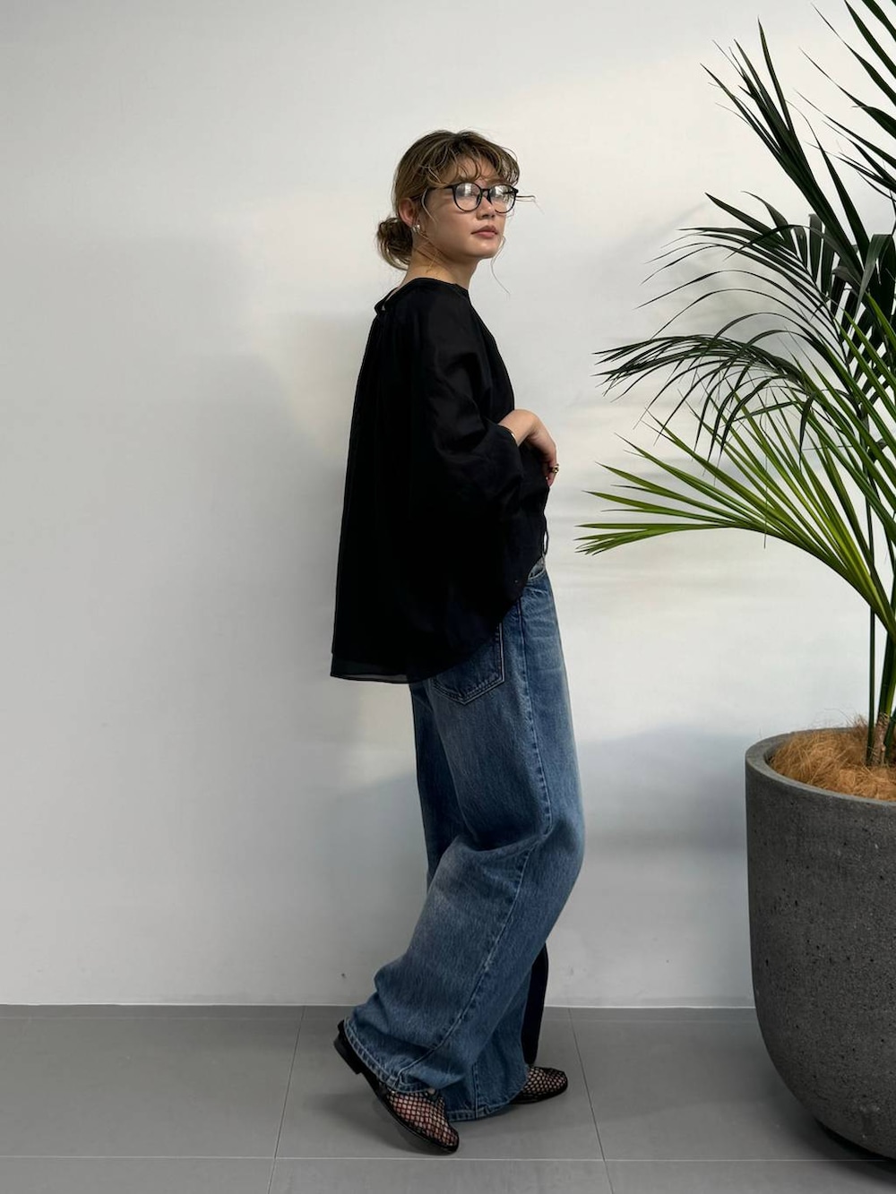 ブラック系のシャツ/ブラウス、ブルー系のデニムパンツ、ブルー系のハンドバッグを着用したレディースの夏コーディネートの3枚目の写真