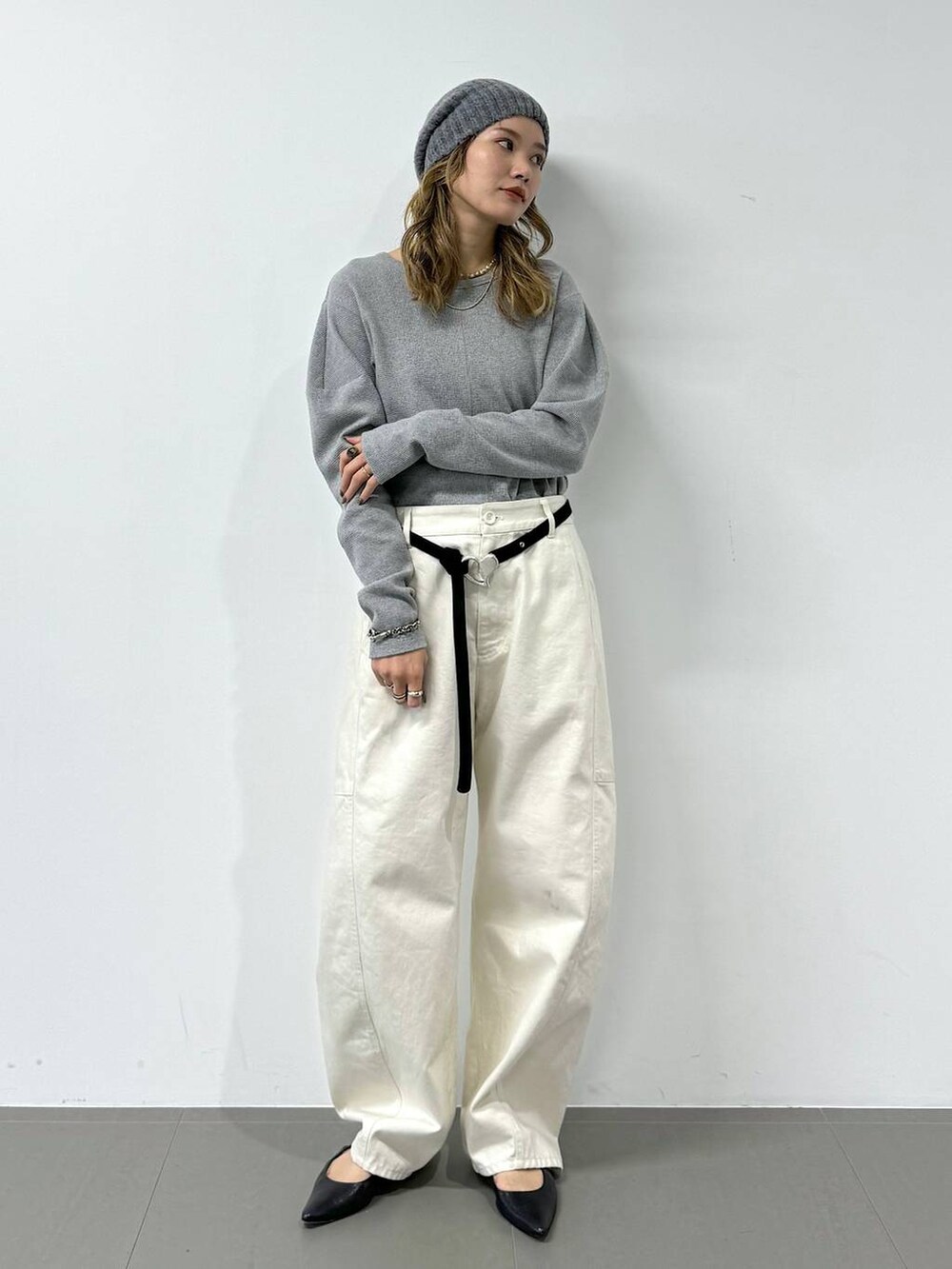 グレー系のTシャツ/カットソー、ホワイト系のその他パンツ、グレー系のニットキャップ/ビーニーを着用したレディースの冬コーディネートの2枚目の写真