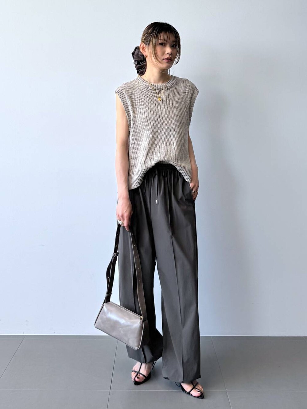 ブラック系のサンダル、グレー系のその他パンツ、ベージュ系のTシャツ/カットソーを着用したレディースの春コーディネートの4枚目の写真