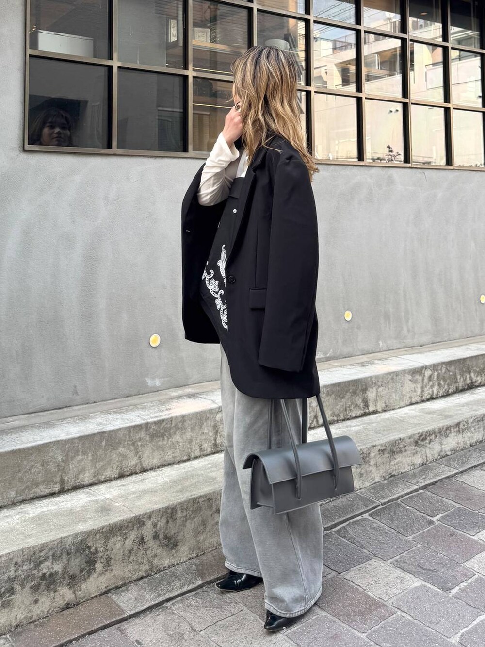 グレー系のデニムパンツ、ブラック系のテーラードジャケット、ホワイト系のTシャツ/カットソーを着用したレディースの春コーディネートの6枚目の写真