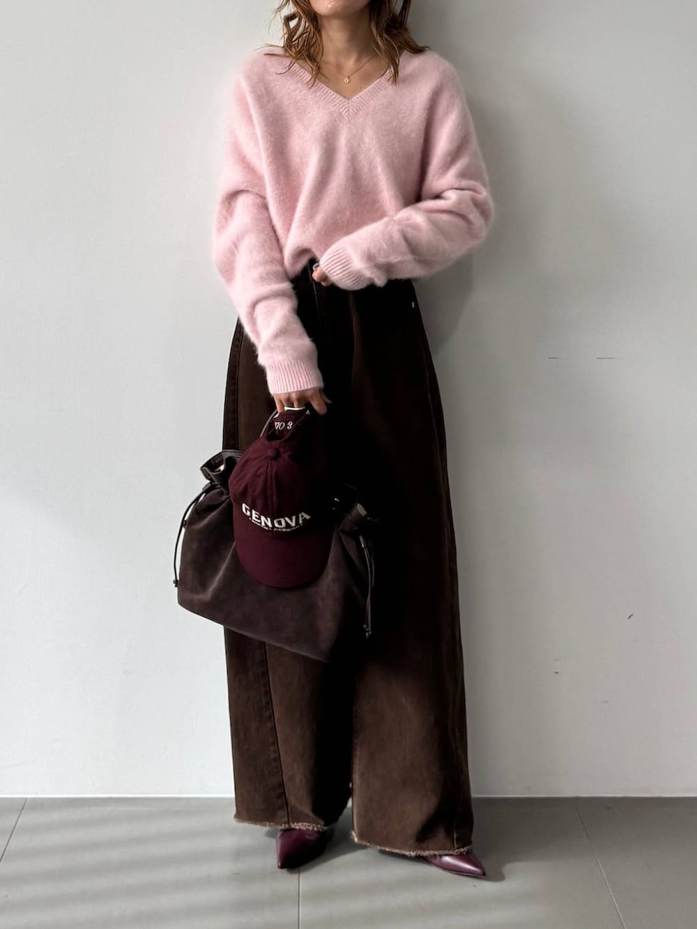 ピンク系のニット/セーター、レッド系のブーツ、ブラウン系のトートバッグを着用したレディースの秋コーディネートの2枚目の写真