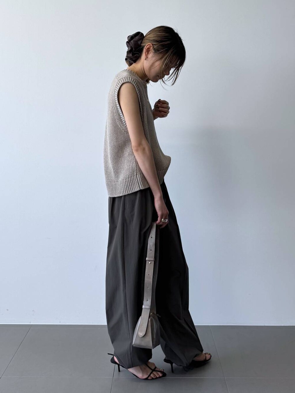 ブラック系のサンダル、グレー系のその他パンツ、ベージュ系のTシャツ/カットソーを着用したレディースの春コーディネートの6枚目の写真