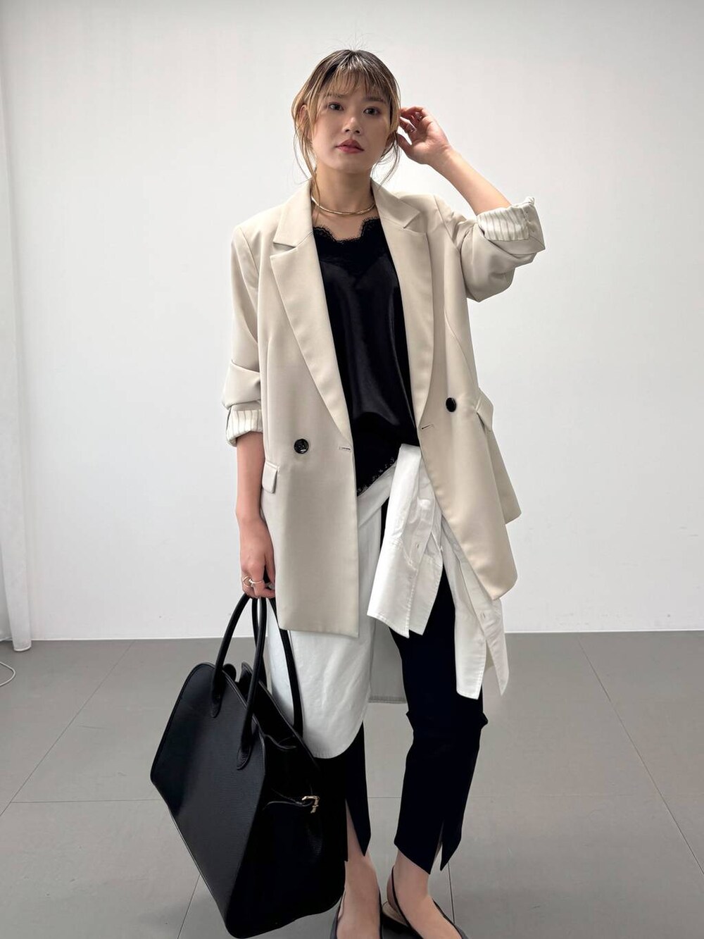 ブラック系のボストンバッグ、ベージュ系のテーラードジャケット、ブラック系のその他パンツを着用したレディースの春コーディネートの6枚目の写真