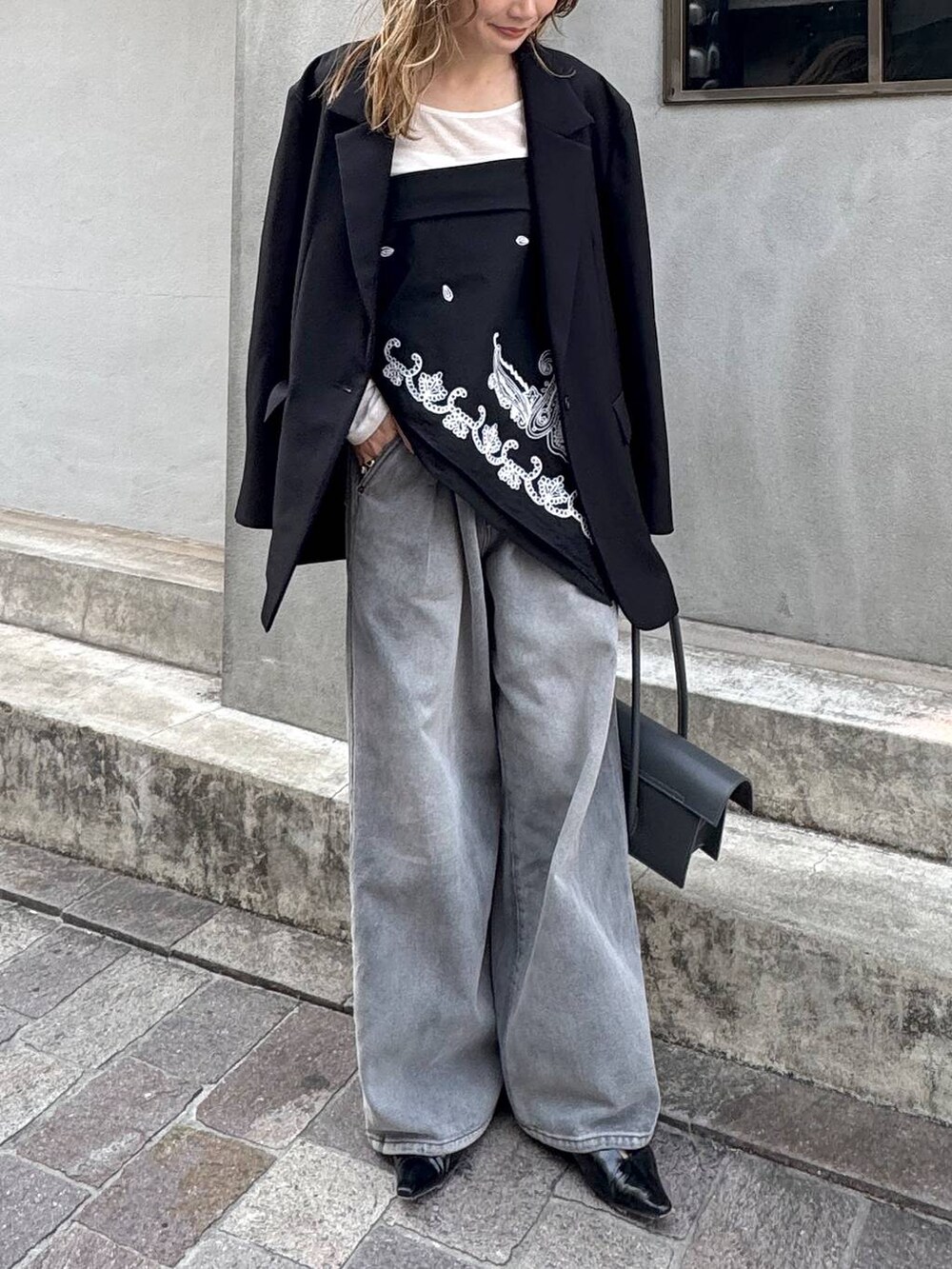 グレー系のデニムパンツ、ブラック系のテーラードジャケット、ホワイト系のTシャツ/カットソーを着用したレディースの春コーディネートの3枚目の写真