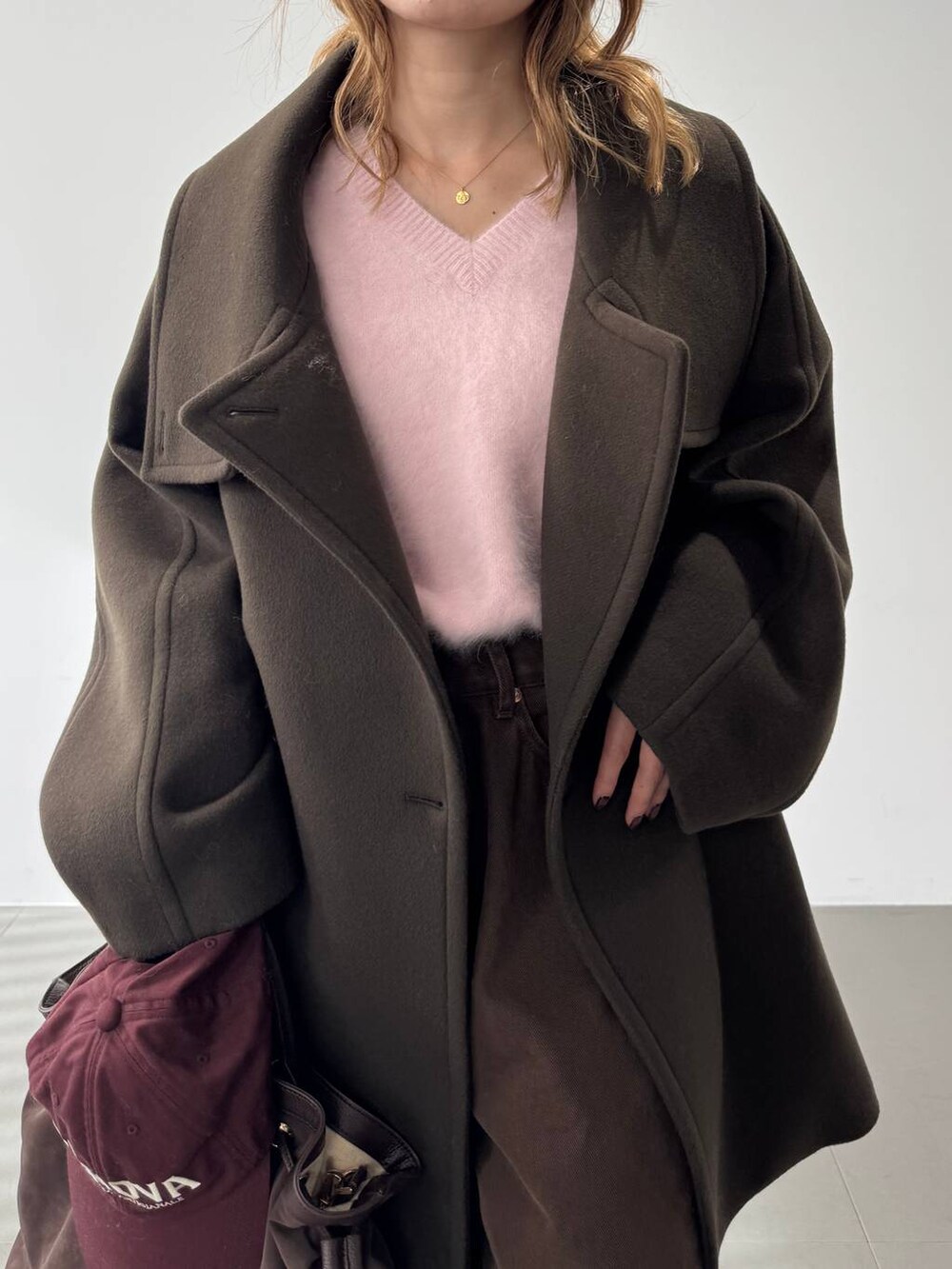 ピンク系のニット/セーター、レッド系のブーツ、ブラウン系のピーコートを着用したレディースの秋コーディネートの8枚目の写真