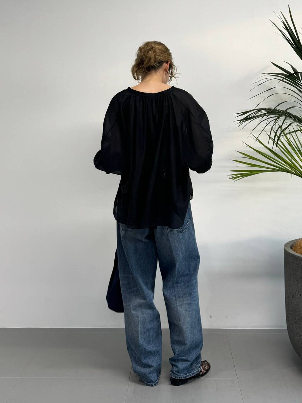 ブラック系のシャツ/ブラウス、ブルー系のデニムパンツ、ブルー系のハンドバッグを着用したレディースの夏コーディネートの6枚目の写真