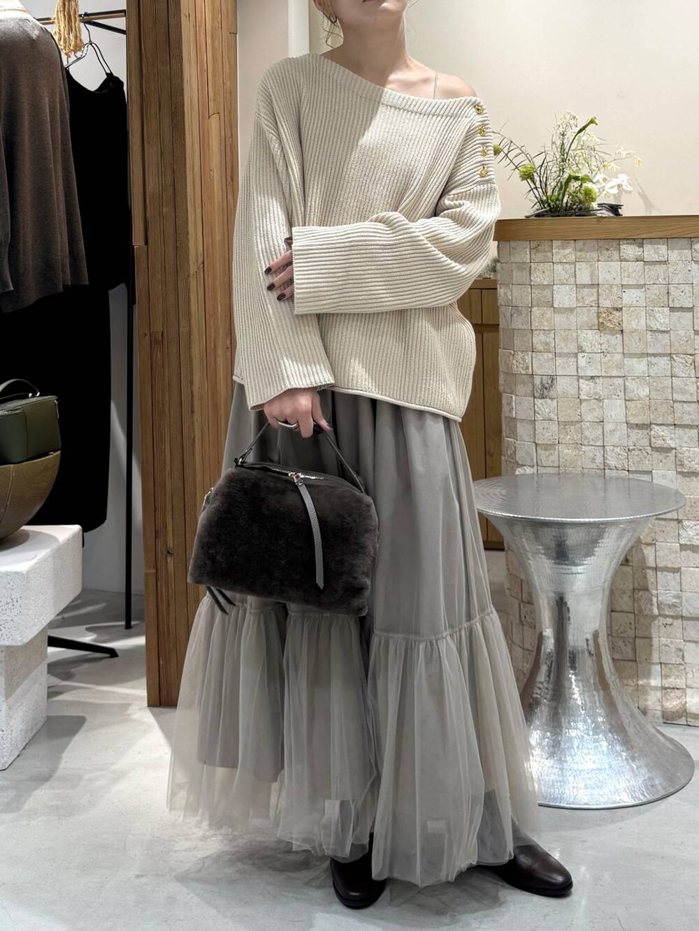 ブラウン系のハンドバッグ、ベージュ系のニット/セーター、ベージュ系のスカートを着用したレディースの冬コーディネートの4枚目の写真