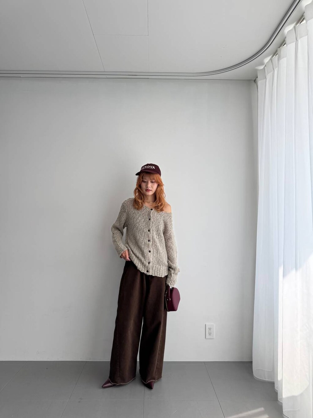 グリーン系のニット/セーター、レッド系のハンドバッグ、レッド系のブーツを着用したレディースの秋コーディネートの4枚目の写真