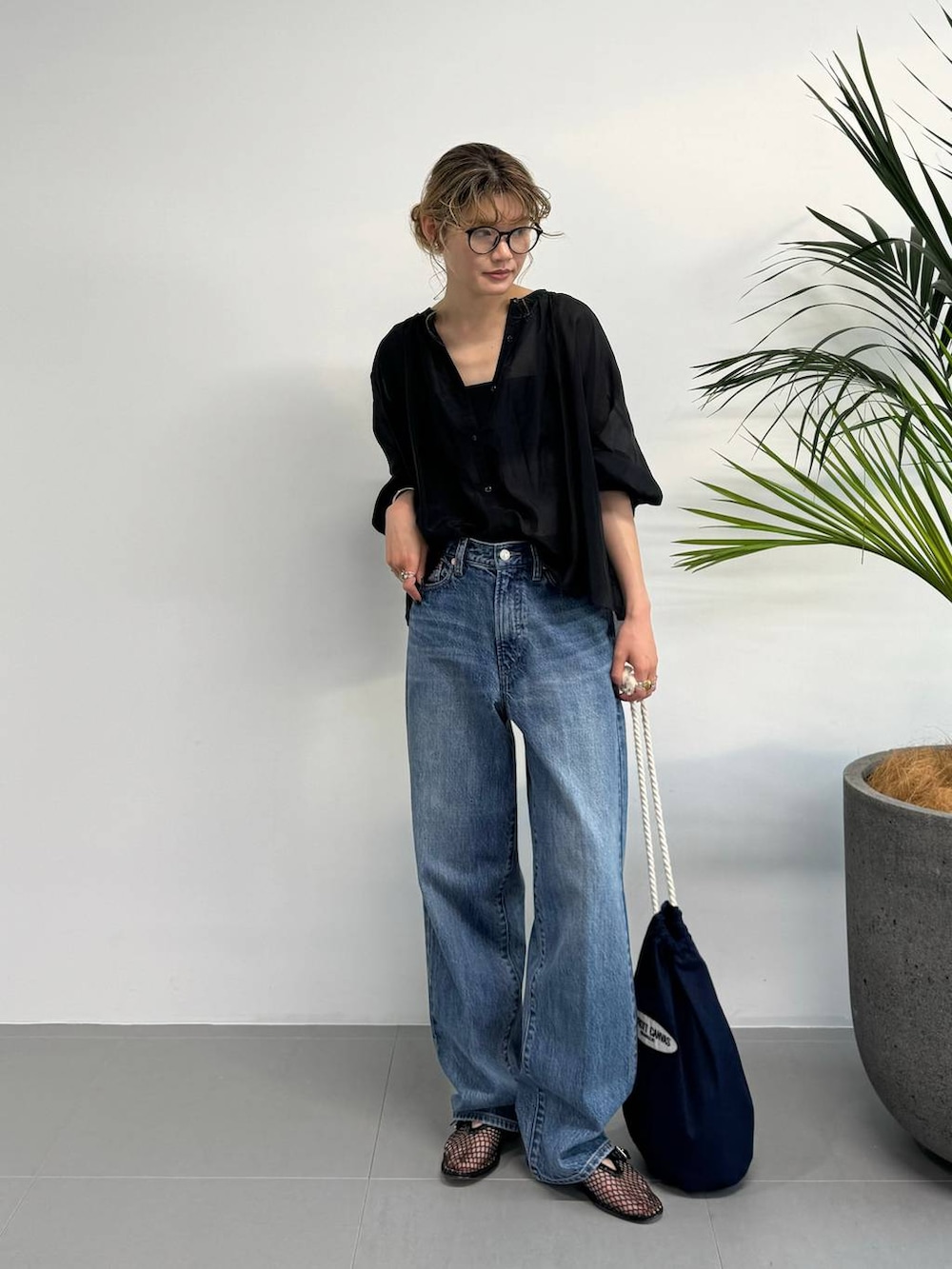 ブラック系のシャツ/ブラウス、ブルー系のデニムパンツ、ブルー系のハンドバッグを着用したレディースの夏コーディネートの4枚目の写真