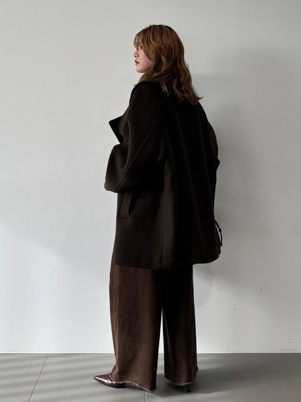 ピンク系のニット/セーター、レッド系のブーツ、ブラウン系のピーコートを着用したレディースの秋コーディネートの7枚目の写真