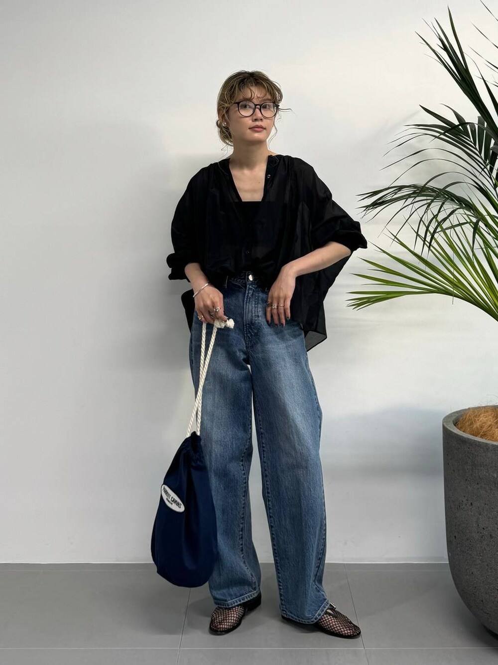 ブラック系のシャツ/ブラウス、ブルー系のデニムパンツ、ブルー系のハンドバッグを着用したレディースの夏コーディネートの8枚目の写真