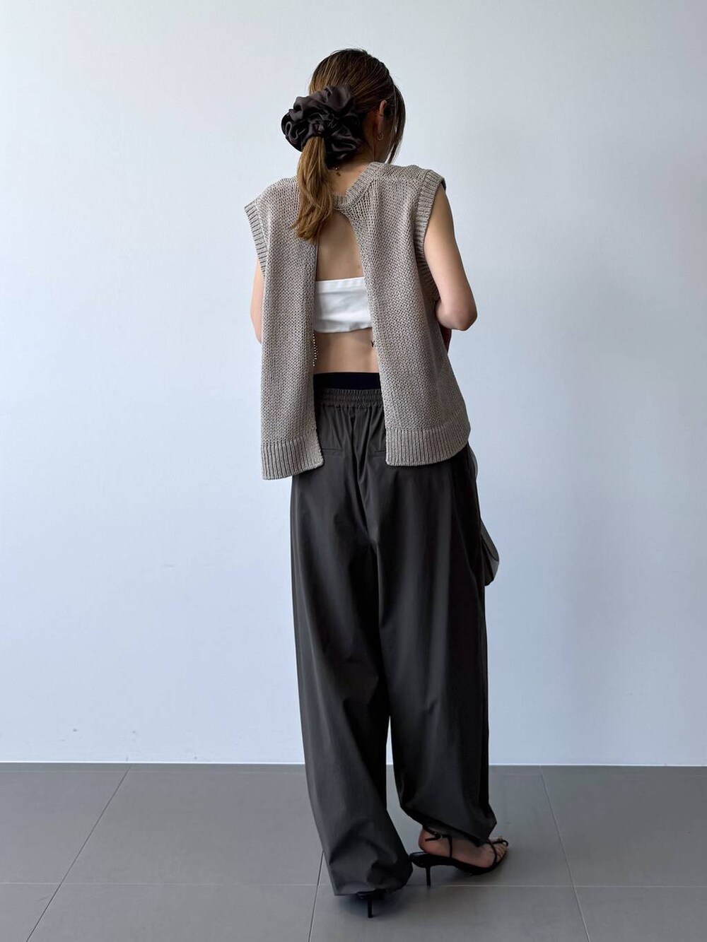 ブラック系のサンダル、グレー系のその他パンツ、ベージュ系のTシャツ/カットソーを着用したレディースの春コーディネートの8枚目の写真