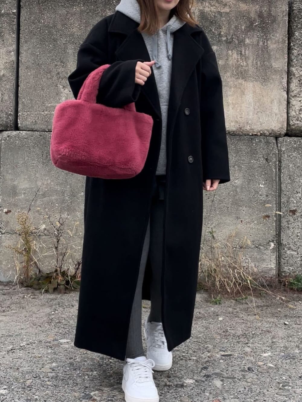 ブラック系のジャケット/アウター、ピンク系のハンドバッグ、グレー系のパーカーを着用したレディースの冬コーディネートの4枚目の写真