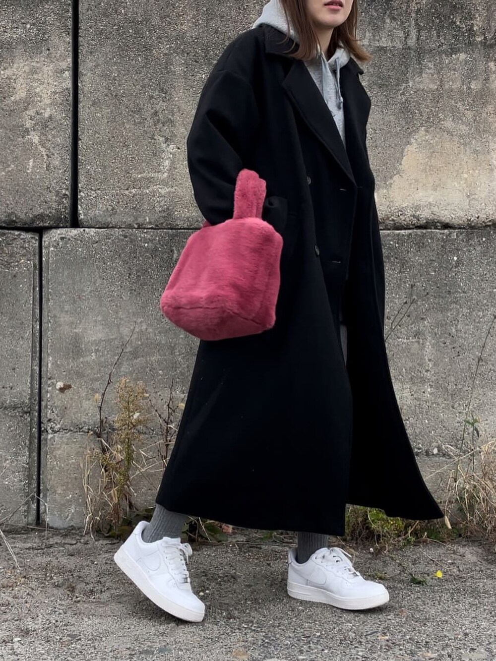 ブラック系のジャケット/アウター、ピンク系のハンドバッグ、グレー系のパーカーを着用したレディースの冬コーディネートの5枚目の写真