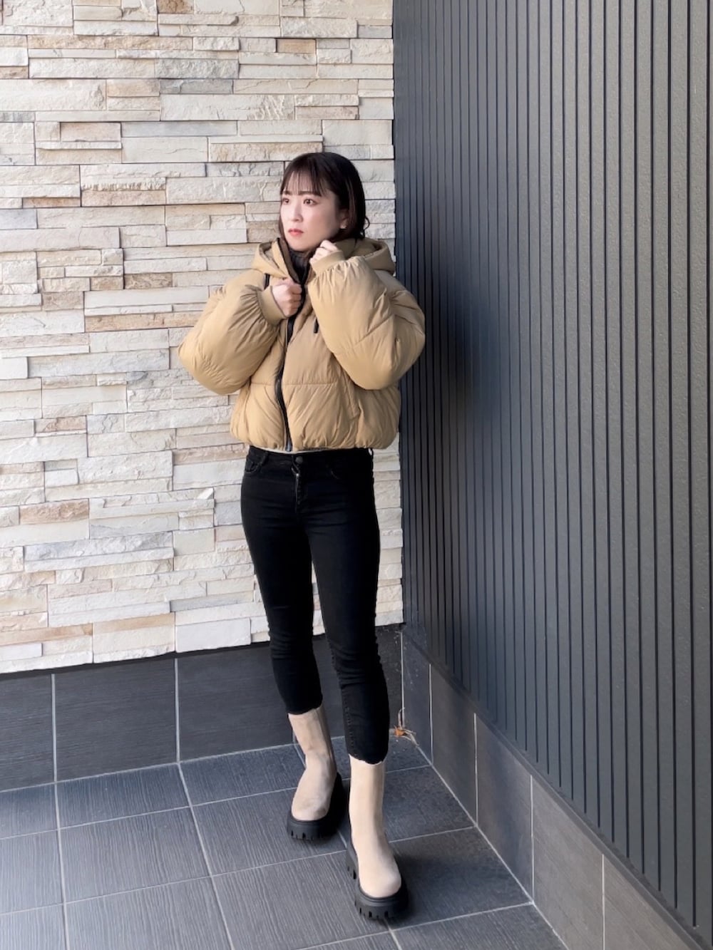 ブラック系のその他パンツ、ベージュ系のブーツ、ベージュ系のダウンジャケット/コートを着用したレディースの冬コーディネートの4枚目の写真