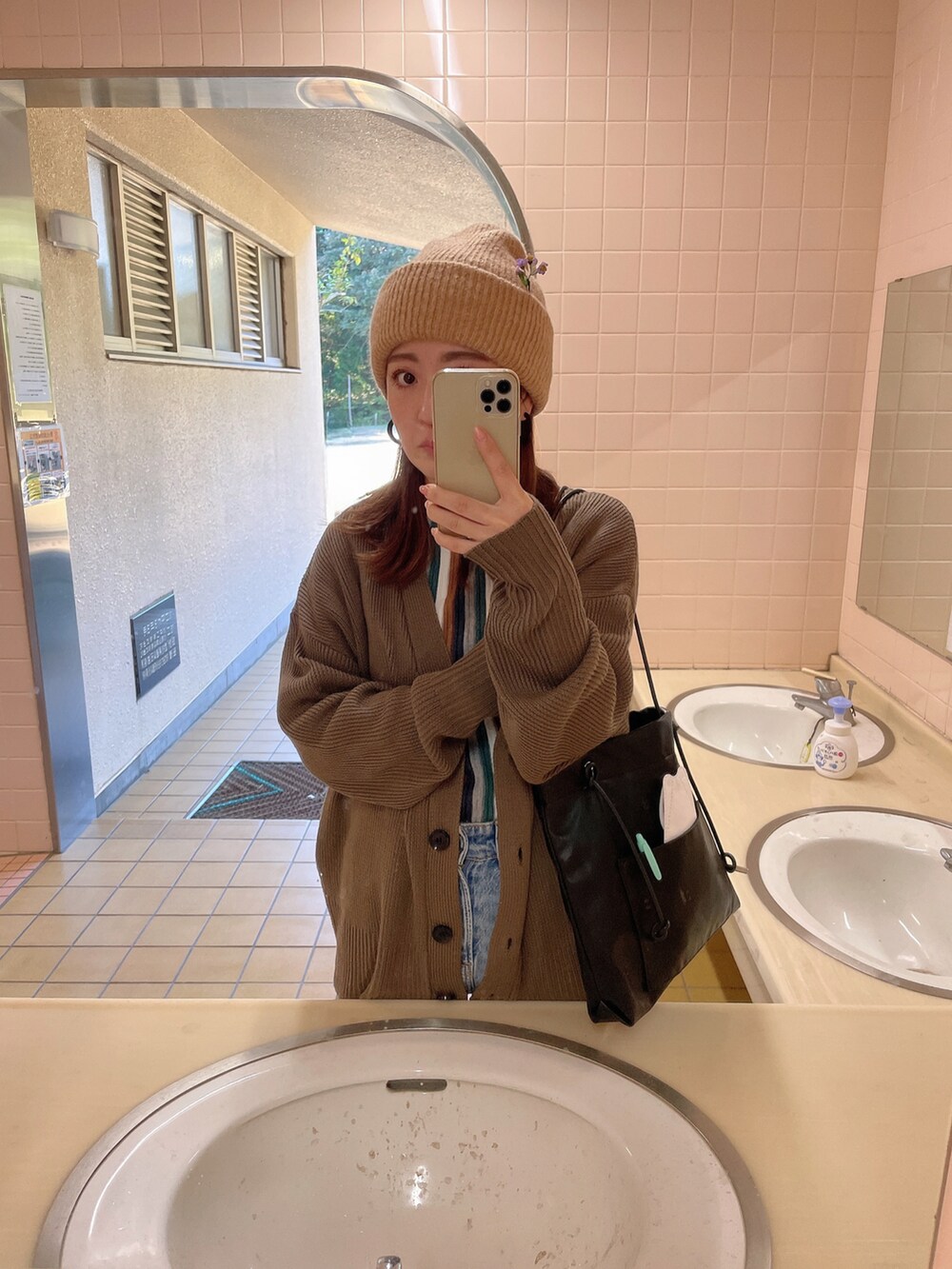 ブルー系のデニムパンツ、ブラック系のショルダーバッグ、グリーン系のTシャツ/カットソーを着用したレディースの秋コーディネートの2枚目の写真