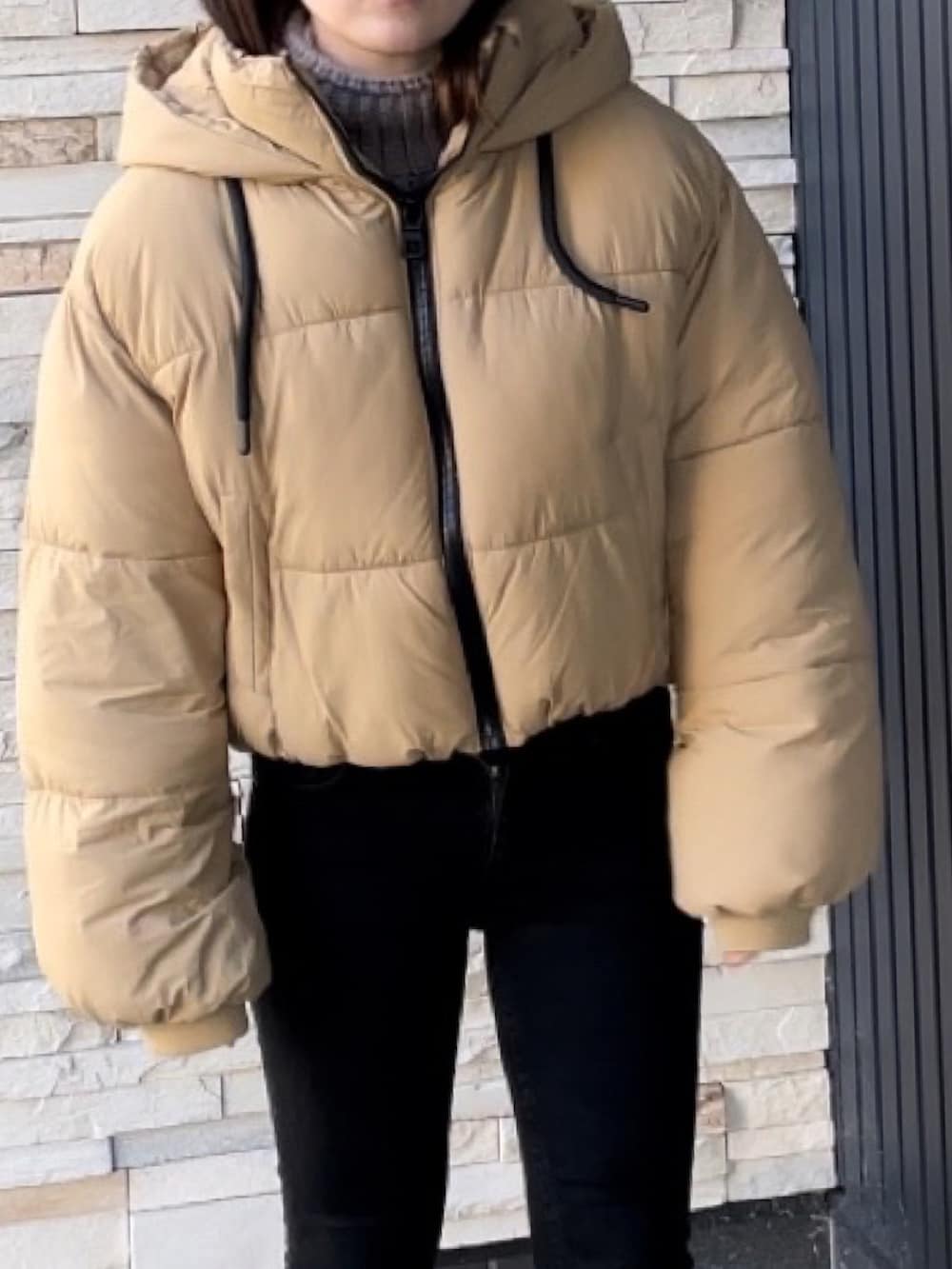 ブラック系のその他パンツ、ベージュ系のブーツ、ベージュ系のダウンジャケット/コートを着用したレディースの冬コーディネートの3枚目の写真