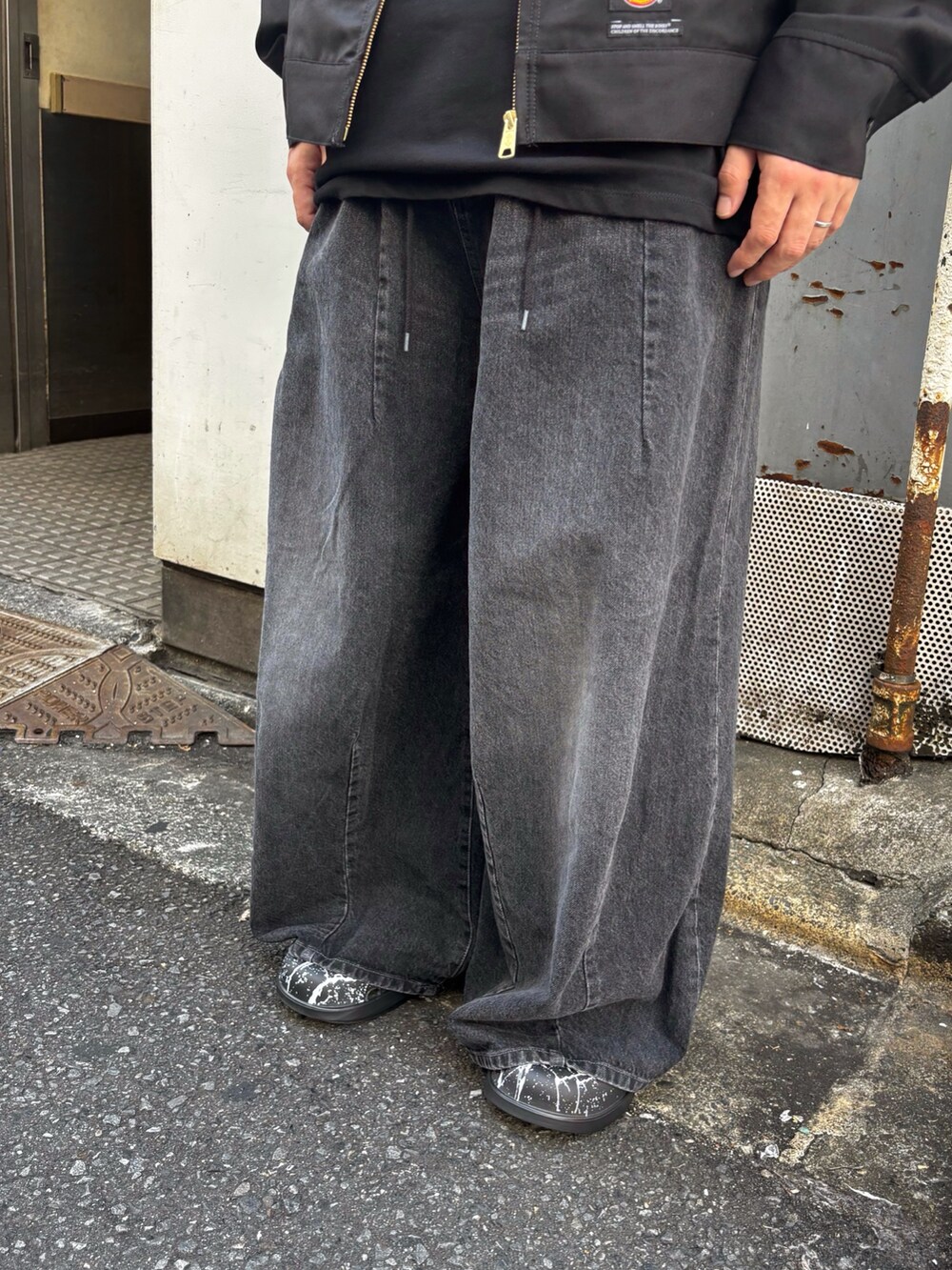 ブラック系のその他アウター、ブラック系のTシャツ/カットソー、ブラック系のサンダルを着用したメンズの秋コーディネートの2枚目の写真