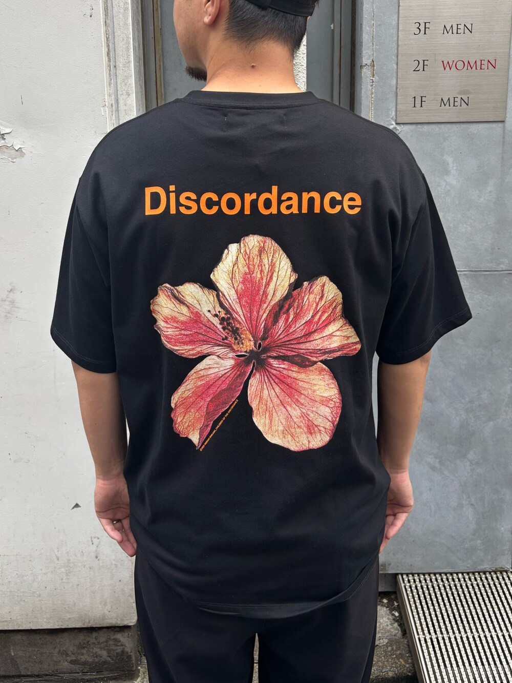 ブラック系のTシャツ/カットソー、ブラック系のサンダル、ブラック系のキャップを着用したメンズの夏コーディネートの2枚目の写真