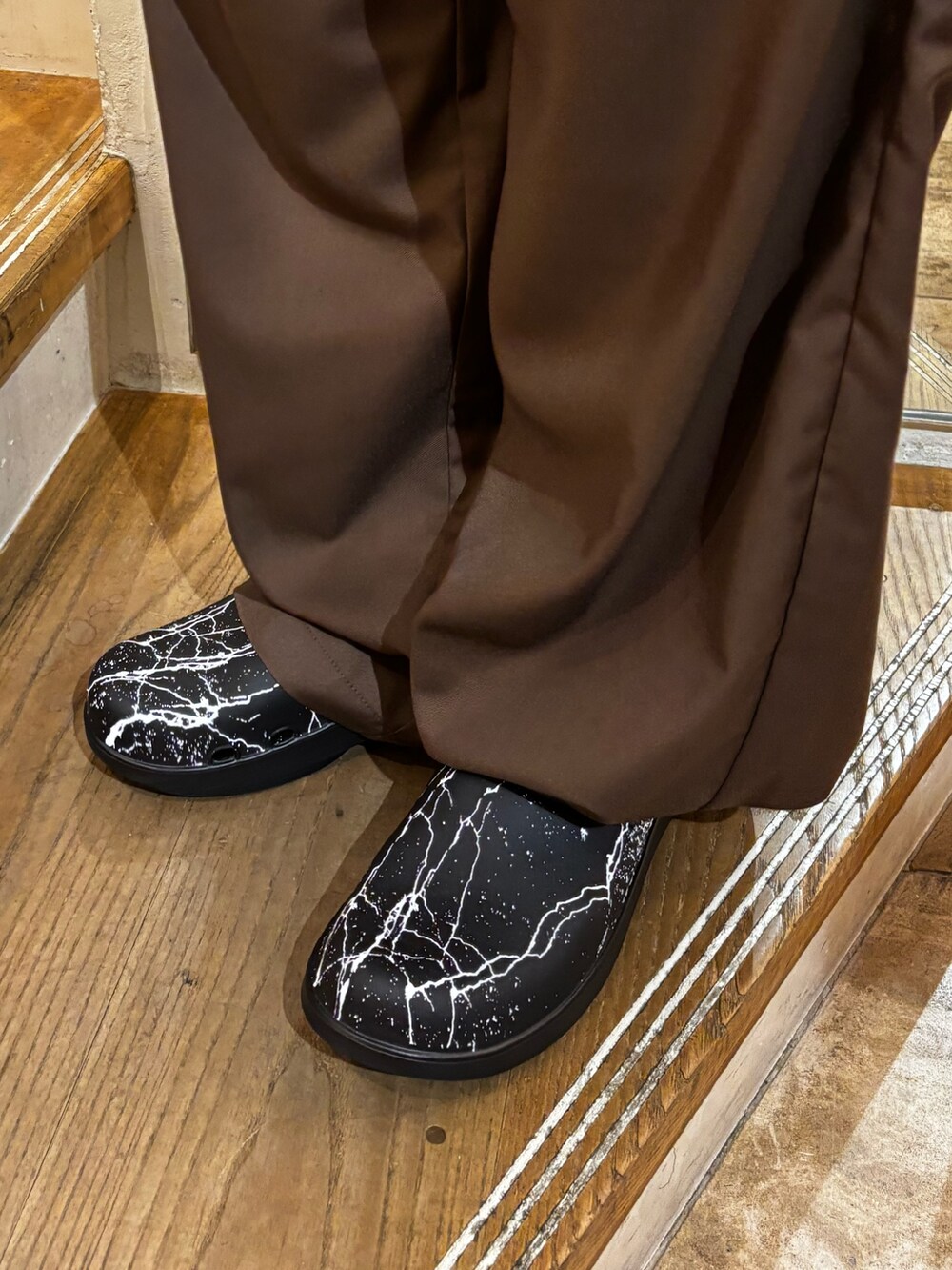ブラウン系のチノパンツ、ブラック系のサンダルを着用したメンズの秋コーディネートの3枚目の写真