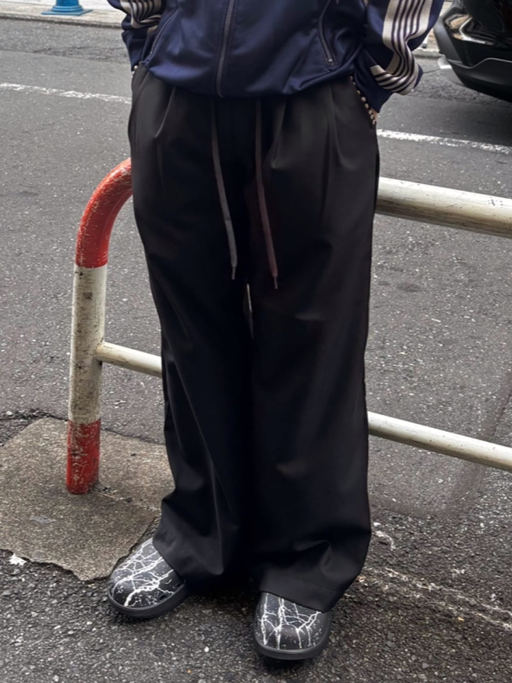 ブラック系のチノパンツ、ブラック系のサンダルを着用したメンズの秋コーディネートの3枚目の写真