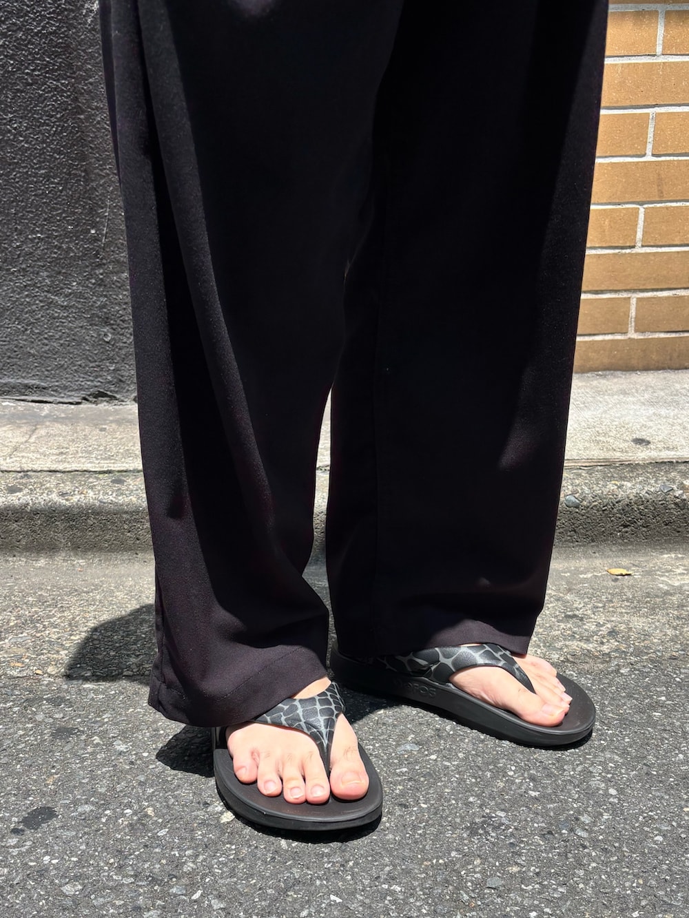 ホワイト系のTシャツ/カットソー、ブラック系のサンダル、ブラック系のキャップを着用したメンズの夏コーディネートの3枚目の写真