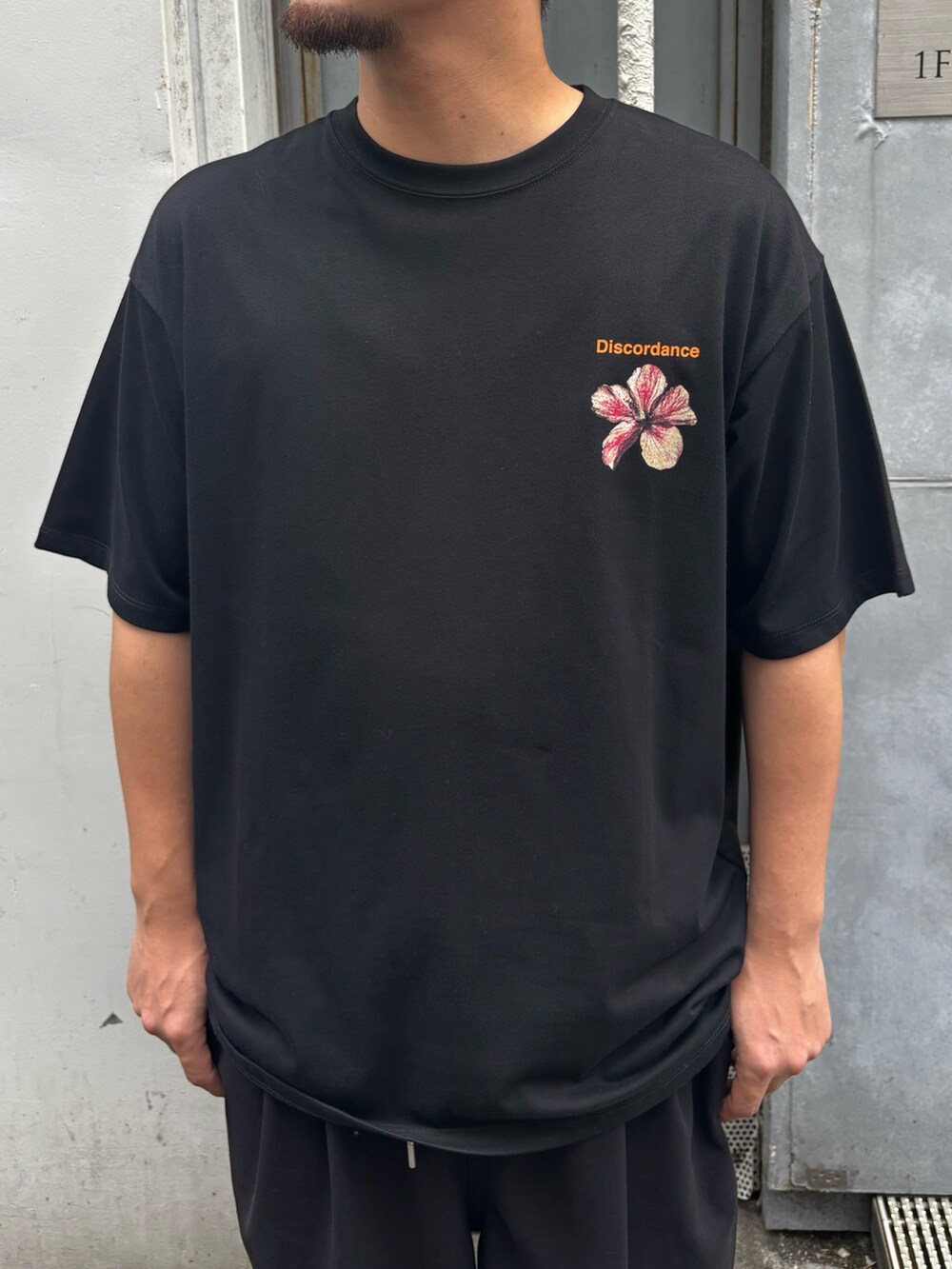 ブラック系のTシャツ/カットソー、ブラック系のサンダル、ブラック系のキャップを着用したメンズの夏コーディネートの3枚目の写真