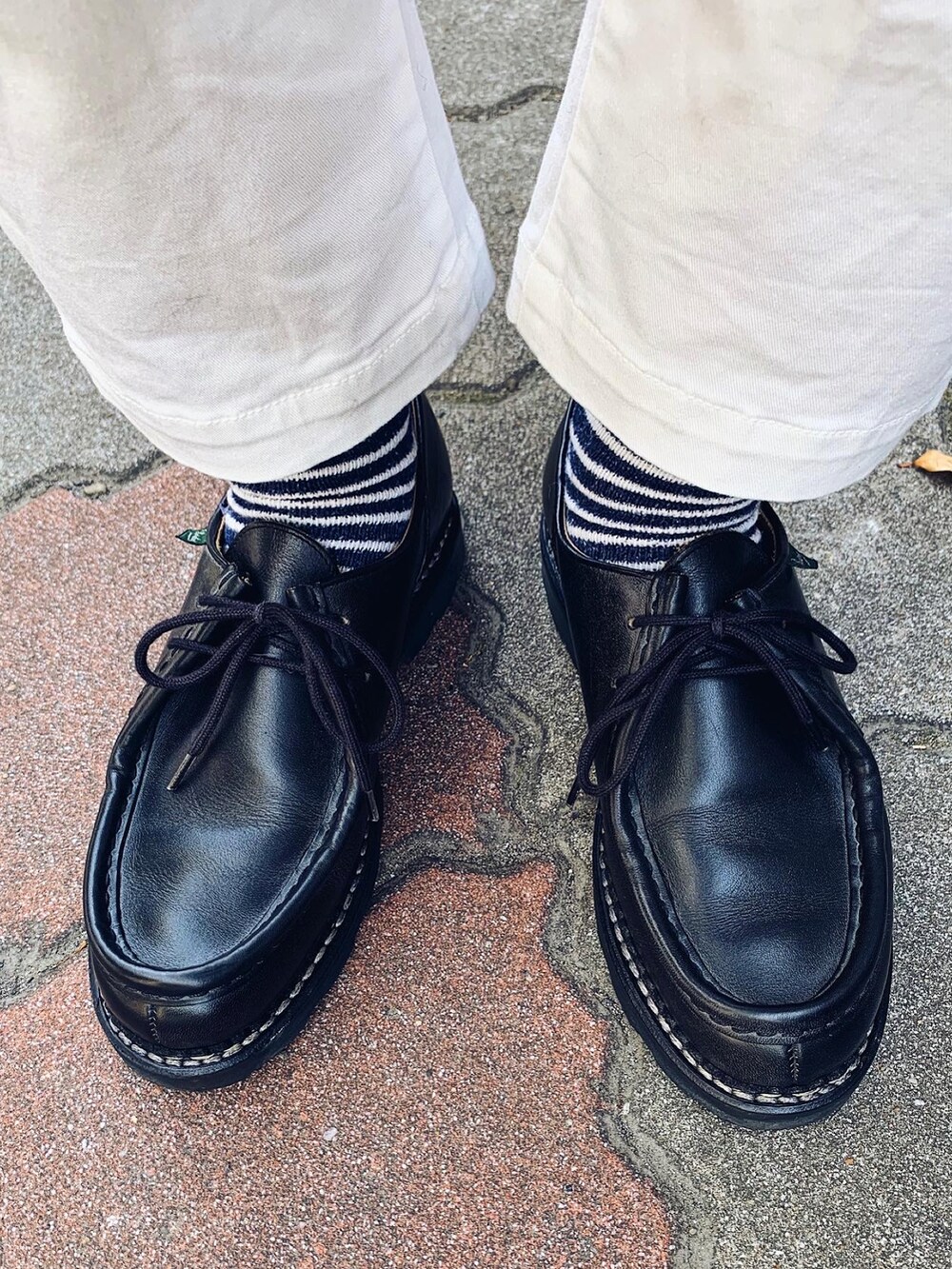 ホワイト系のデニムパンツ、ブラック系のブーツ、イエロー系の手袋を着用したメンズの冬コーディネートの3枚目の写真