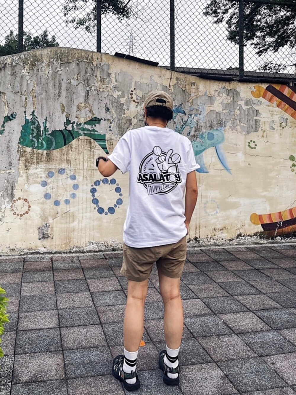 ベージュ系のカーゴパンツ、グリーン系のサンダル、シルバー系のネックレスを着用したメンズの夏コーディネートの2枚目の写真