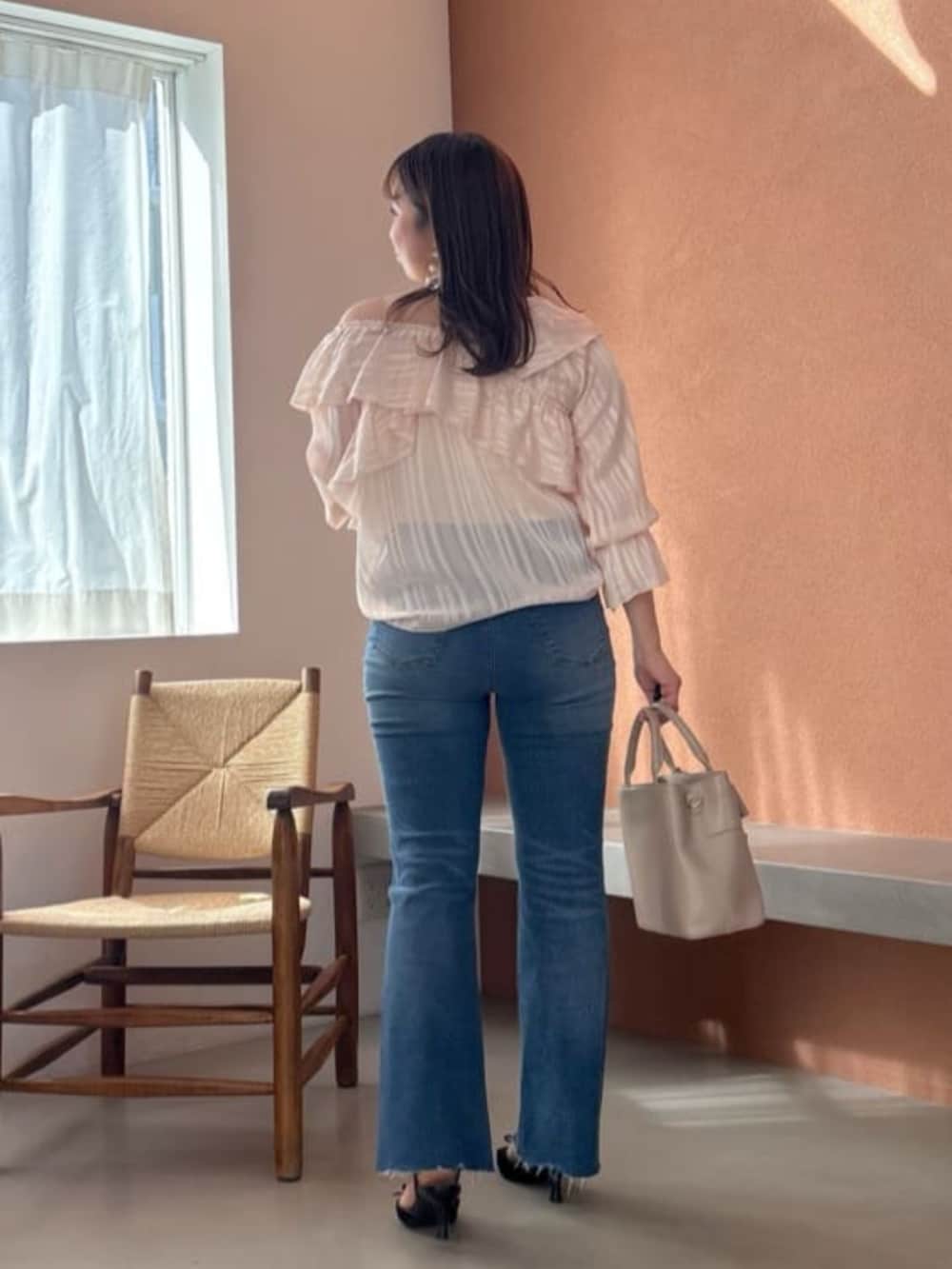 ホワイト系のショルダーバッグ、ブラウン系のショルダーバッグ、ブルー系のデニムパンツを着用したレディースの冬コーディネートの3枚目の写真