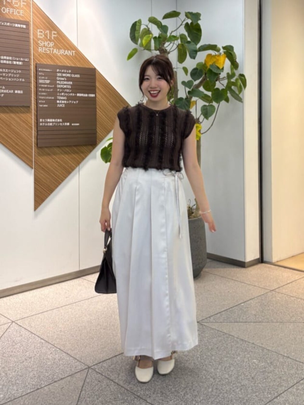 ブラウン系のニット/セーターを着用したレディースの夏コーディネートの2枚目の写真