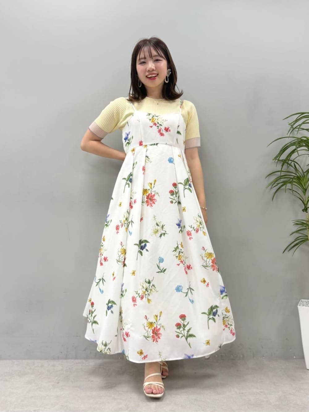 イエロー系のニット/セーター、ホワイト系のワンピースを着用したレディースの夏コーディネートの2枚目の写真