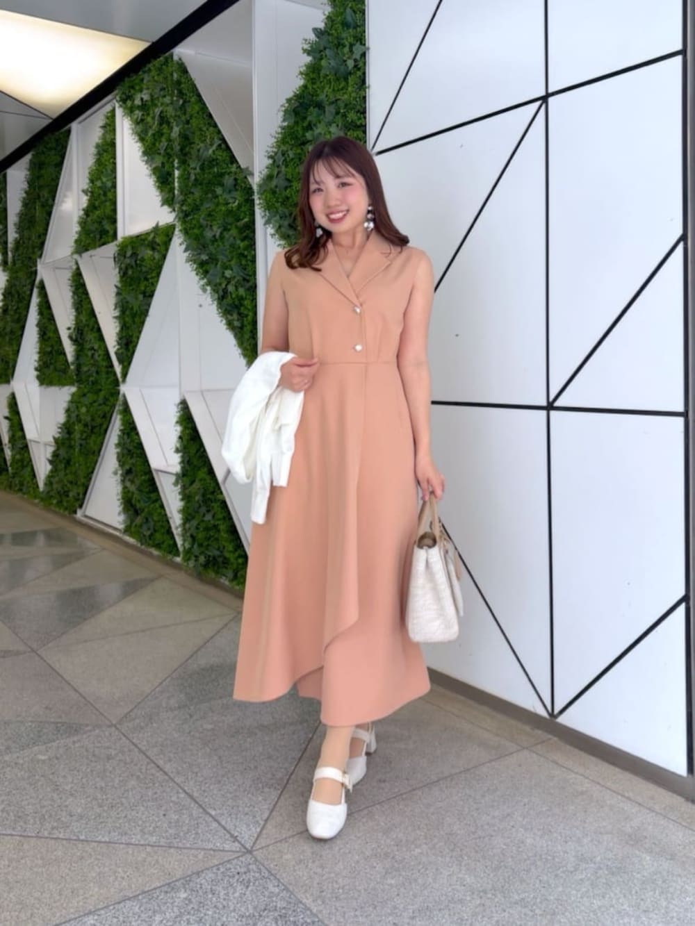 ピンク系のワンピースを着用したレディースの冬コーディネートの2枚目の写真